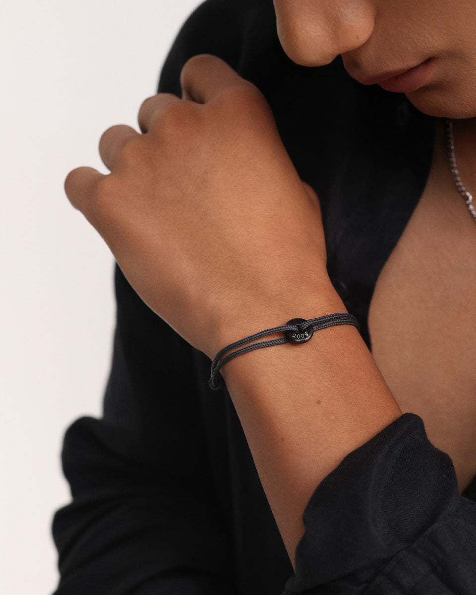 Segeltau Donut Surferarmband in Schwarz mit Jahreszahl-Gravur '2008' am Handgelenk