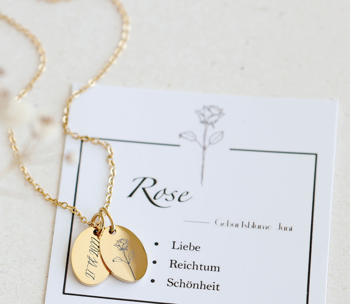 Goldkette mit graviertem Datum und Rosen-Motiv auf Karte zur Geburtsblume Juni