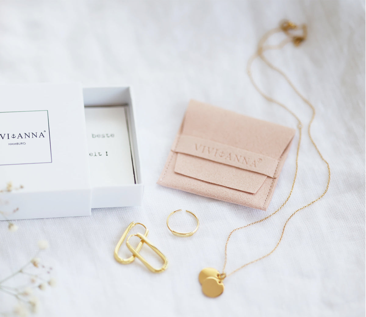 Geschenkbox mit rosafarbenem Beutel, Goldring, Creole und Kette mit Herzanhänger