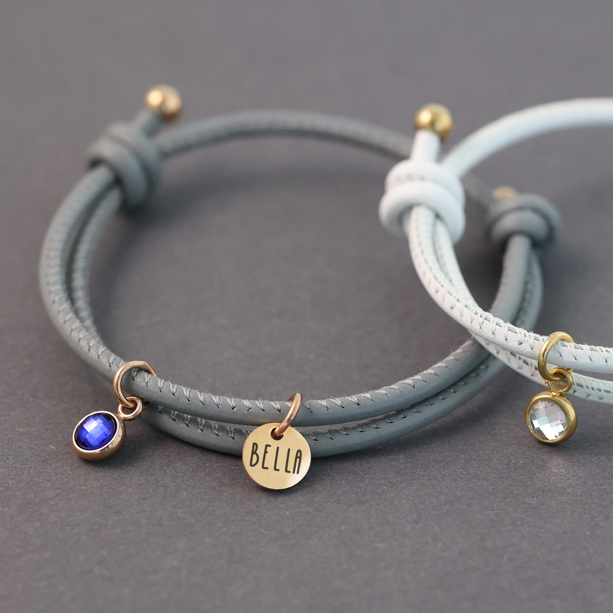 Zusatz-Geburtsstein-Anhänger an Lederarmband mit Gravurplättchen und blauem Stein kombiniert