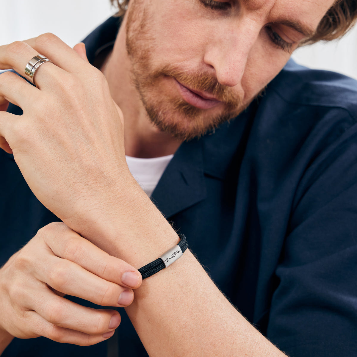 Mann trägt schwarzes Segeltau-Armband mit Gravur am Handgelenk, Nahaufnahme