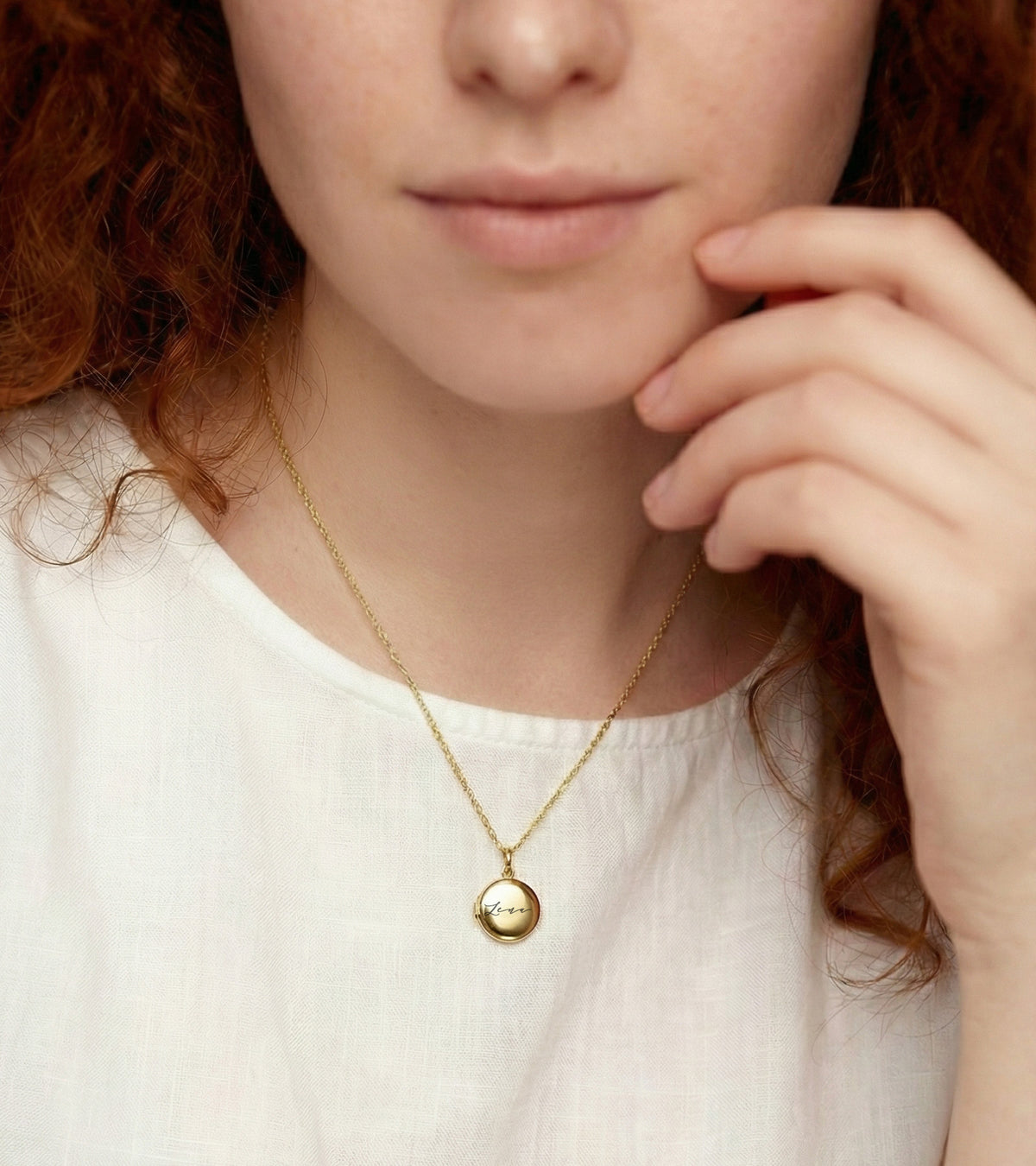 Frau trägt Mini Foto-Medaillon Kette mit Gravur über cremefarbenem Oberteil