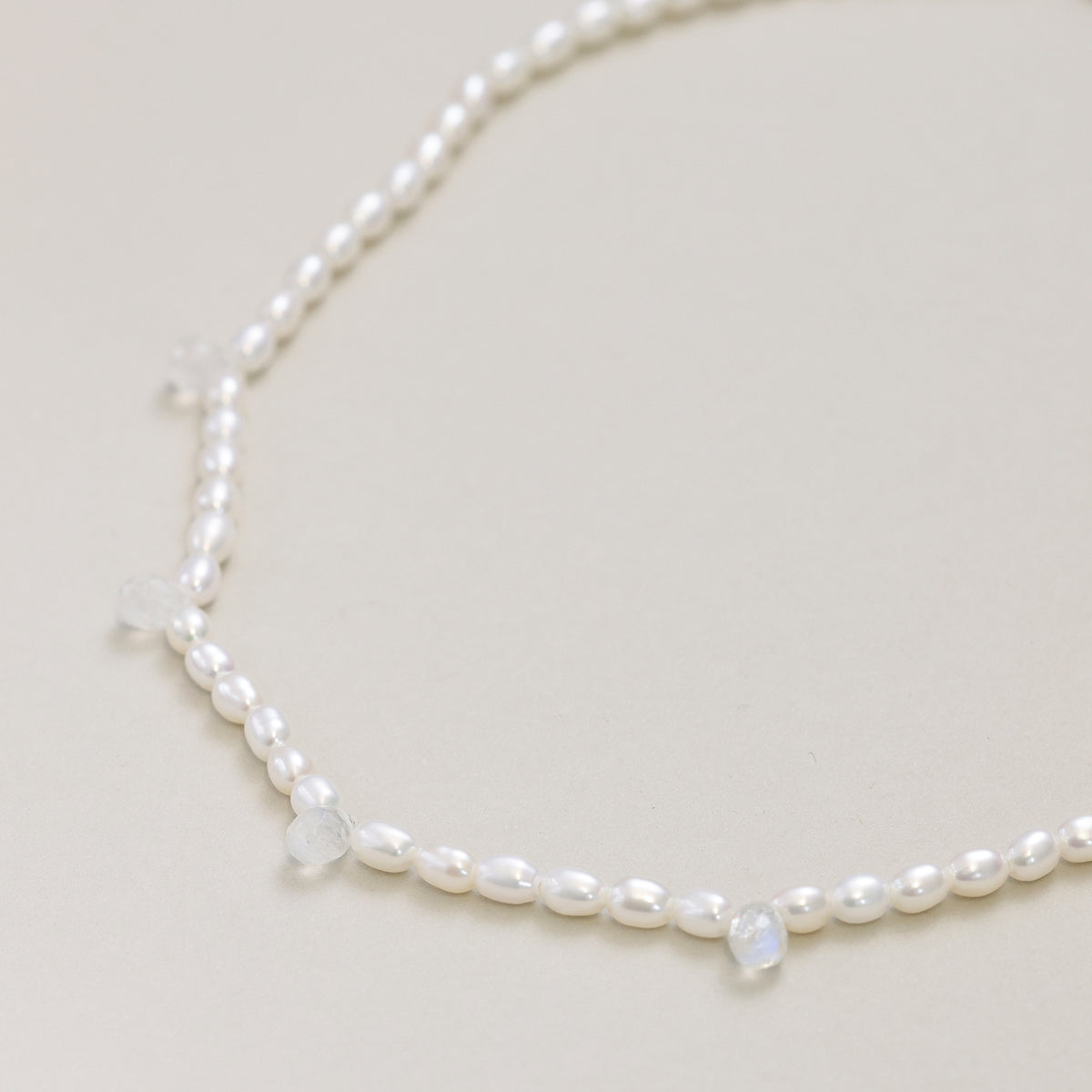 Detailaufnahme der Perlenkette mit mehreren Mondstein-Anhängern entlang der Kette