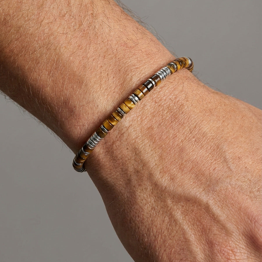 Edelsteinarmband mit Tigerauge und Hämatit am Handgelenk getragen, Nahaufnahme
