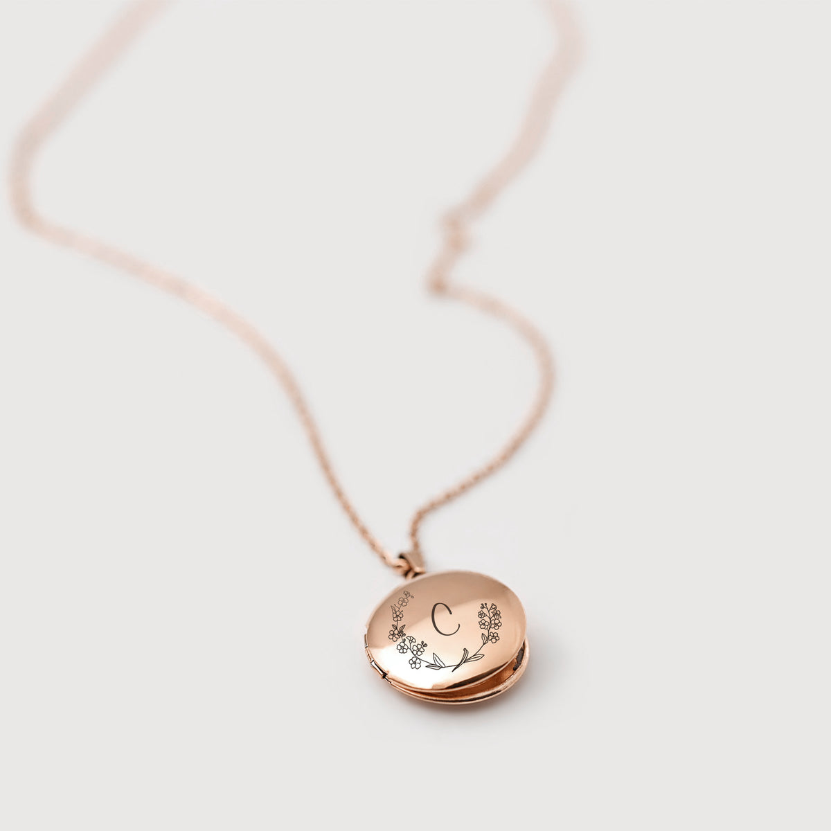 Medaillon Kette mit personalisierter Gravur in Roségold – rundes Medaillon mit Buchstabe 'C' und Blütenzweig