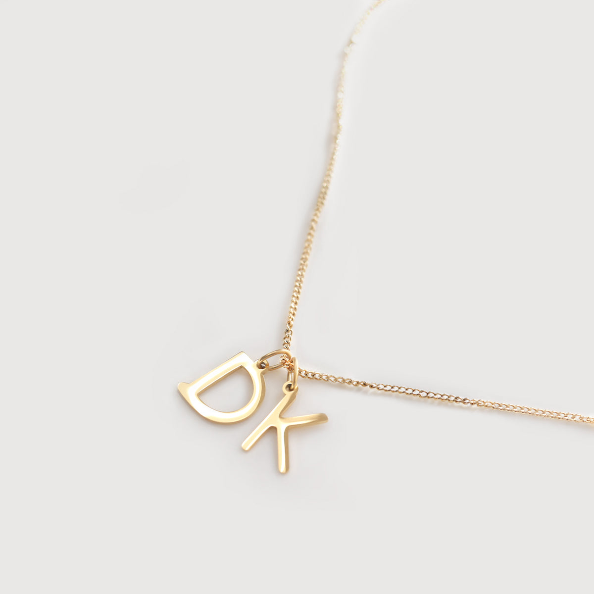 Goldene Kette mit zwei gravierten Buchstaben-Anhängern D und K