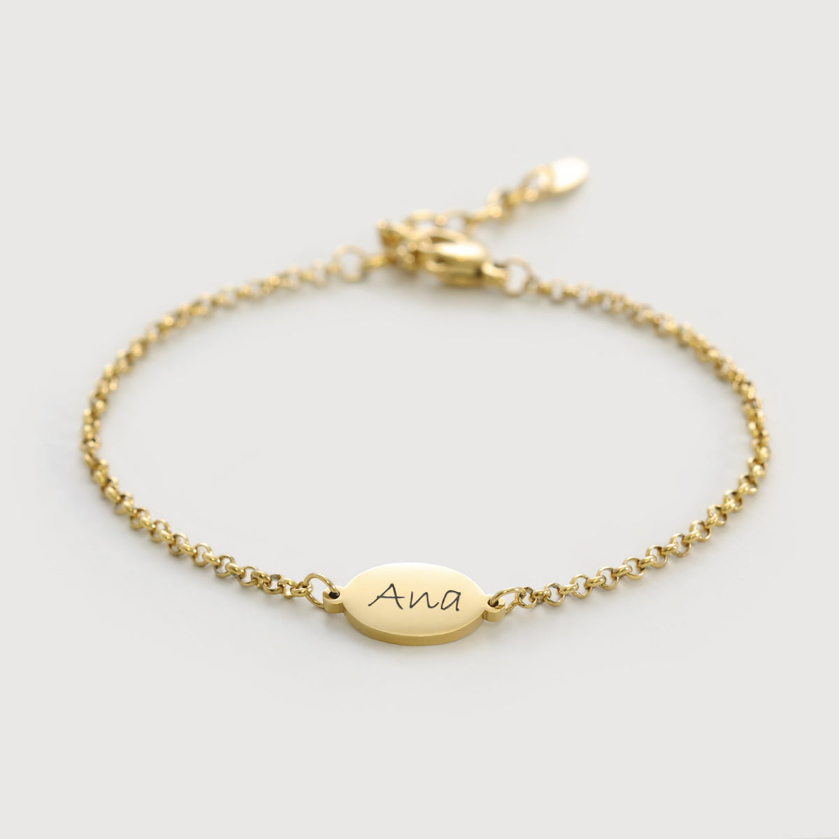 Personalisiertes Armband mit ovalen Plättchen in Gold, flach liegend mit Gravur 'Ana'