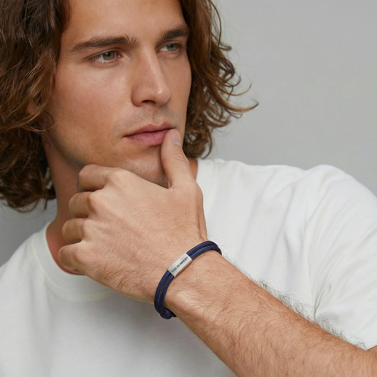Mann trägt personalisiertes Segeltau Armband in Dunkelblau mit Gravurplatte am Handgelenk