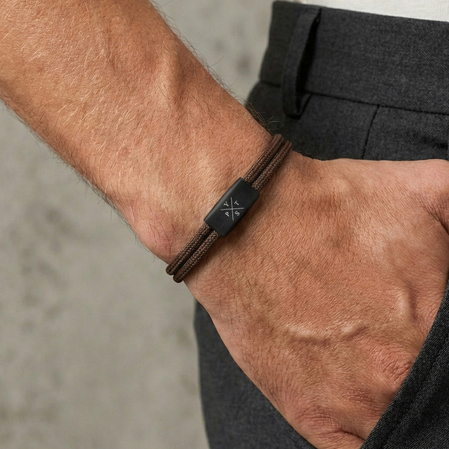 Nahaufnahme: Mann trägt braunes wasserfestes Familien Armband mit Gravur am Handgelenk