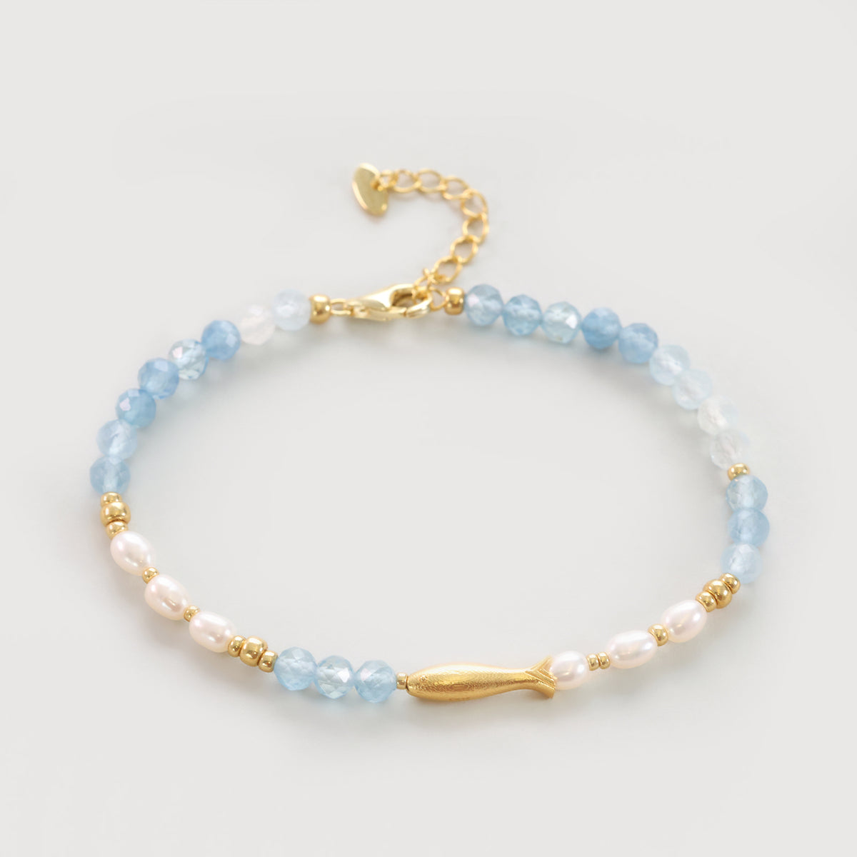 Fisch-Armband mit Aquamarin und Süßwasserperlen in Gold, flach liegend fotografiert