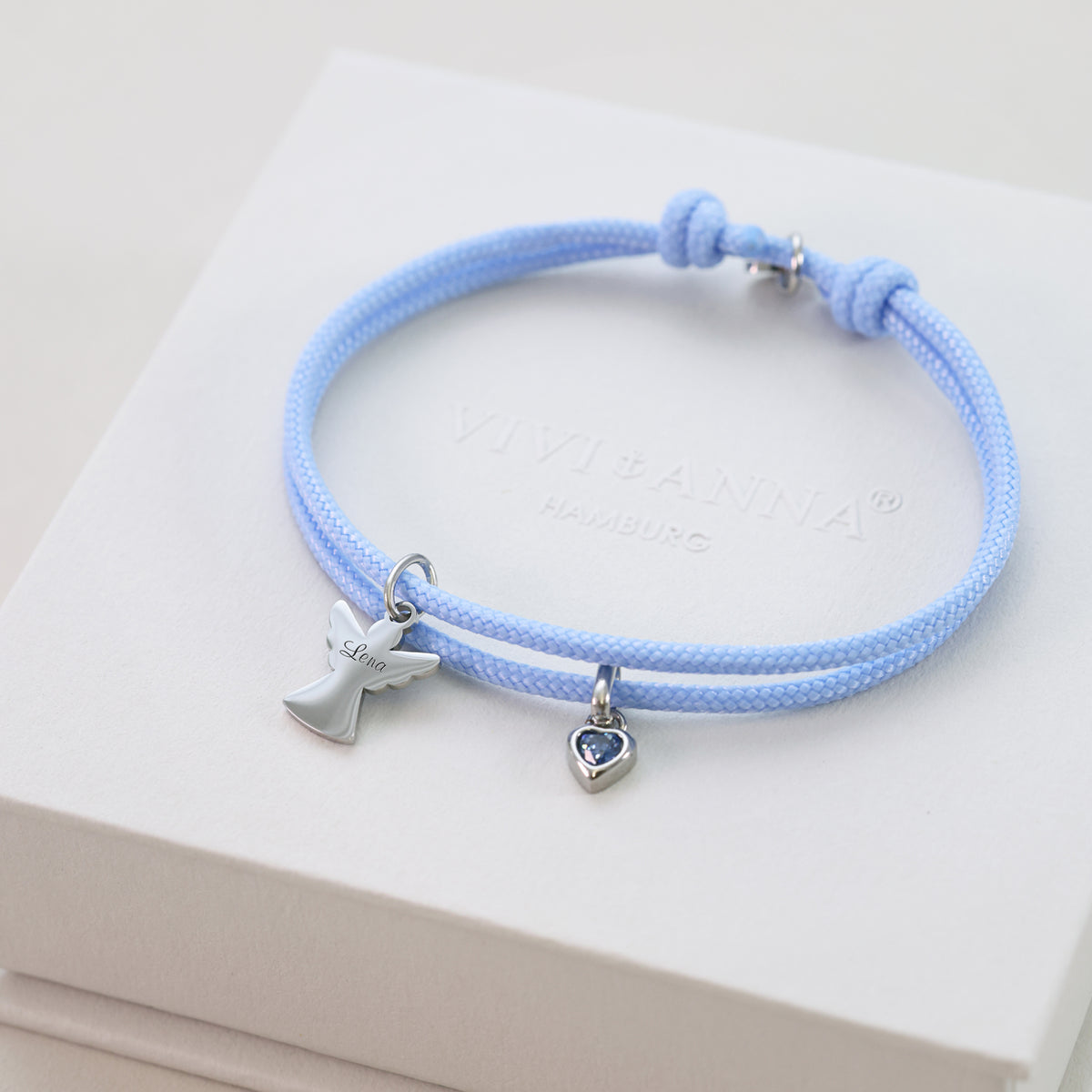 Hellblaues Segeltau Armband mit silbernem Schutzengel, graviert mit Namen Lena, auf VIVI&ANNA Box