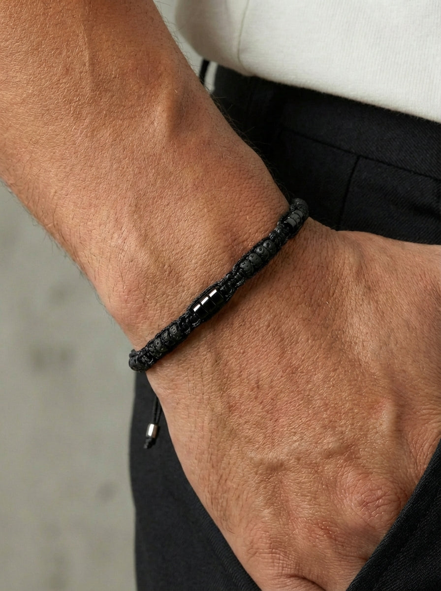 Mann trägt schwarzes Makramee Armband aus Lava-Perlen und Turmalin am Handgelenk