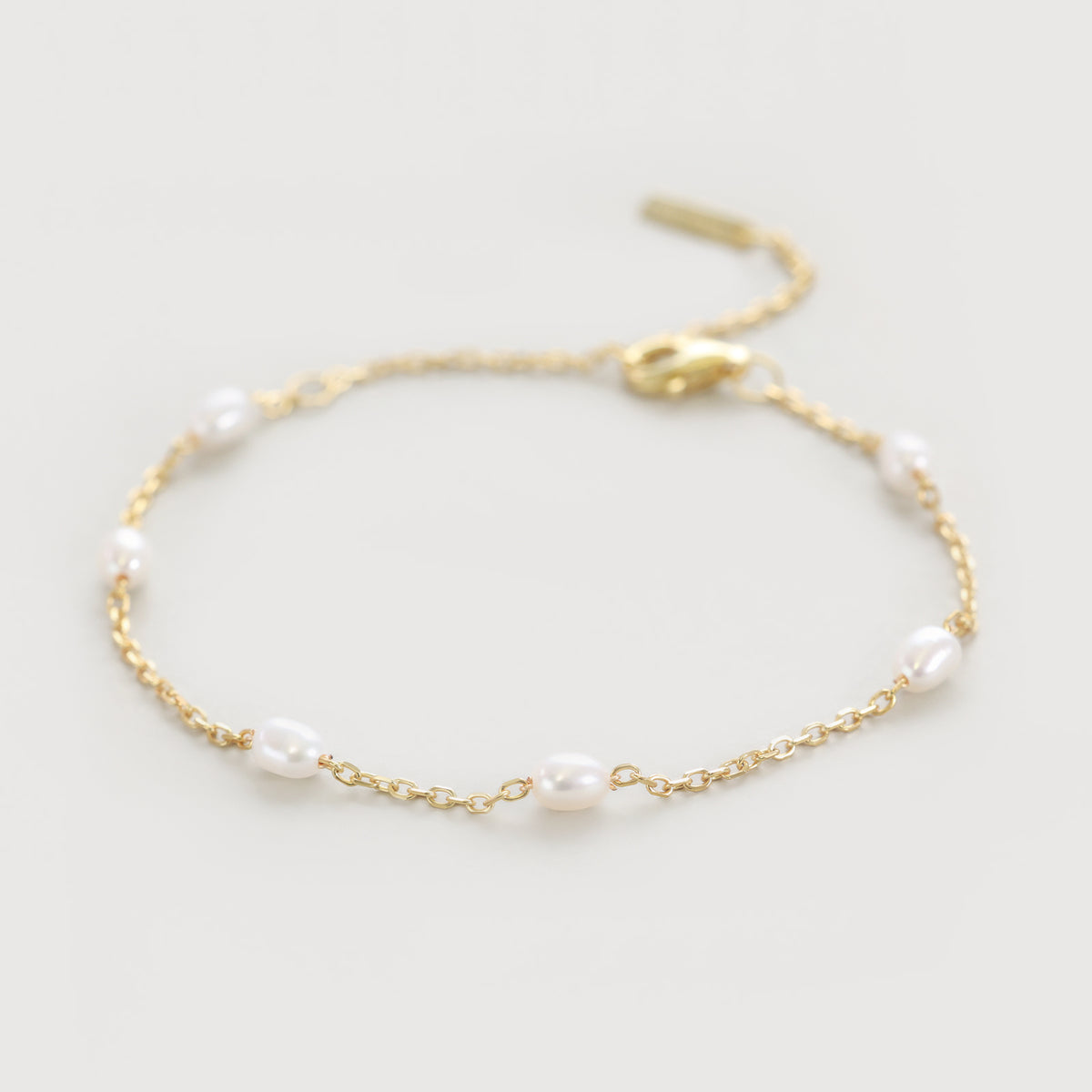 Feines Armband mit kleinen Süßwasserperlen - 925er Sterling Silber, flach ausgelegt mit goldenem Verschluss