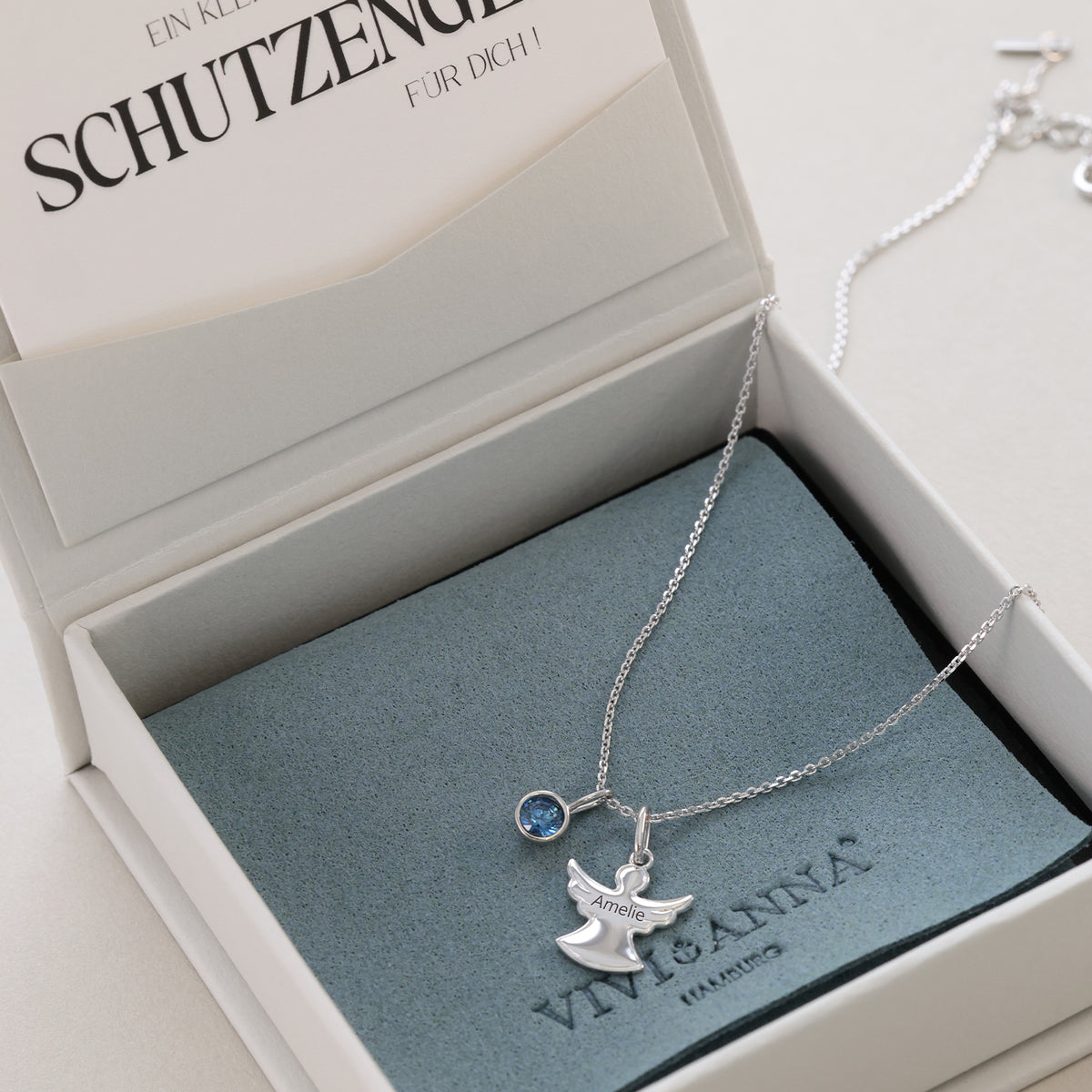 Schutzengel Halskette in Silber mit blauem Geburtsstein und Gravur 'Amelie' in offener Box