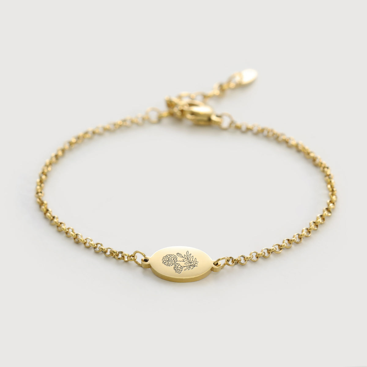 Geburtsblumen-Armband mit ovalem Gravurplättchen in Gold, flach liegend