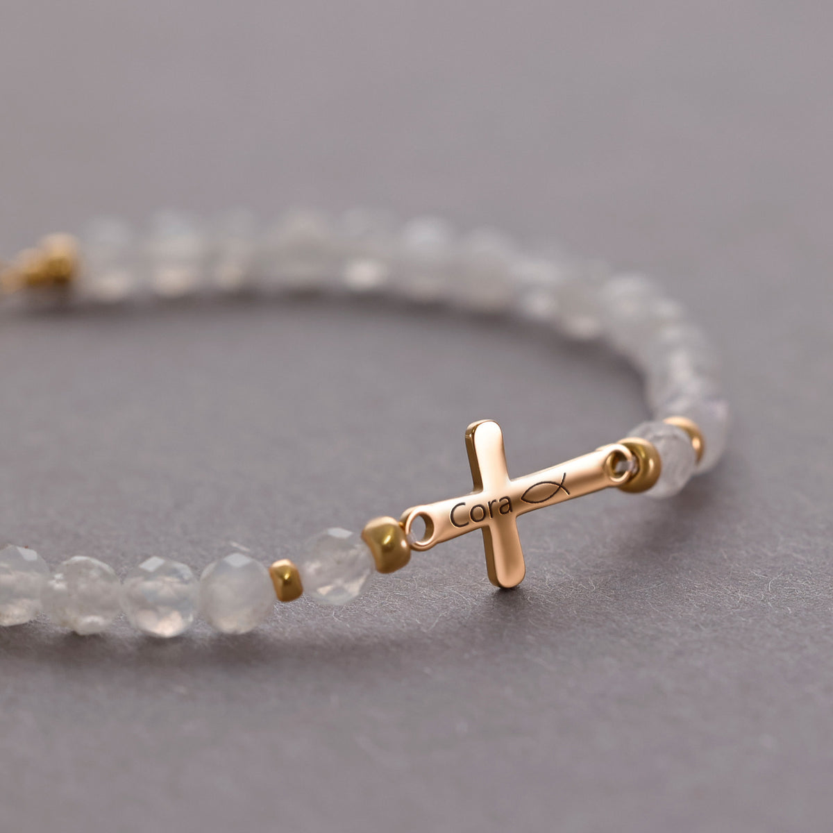 Mondstein Kreuz-Armband mit Gravur in Gold – Kreuz graviert mit Namen 'Cora' und Ichthys-Symbol