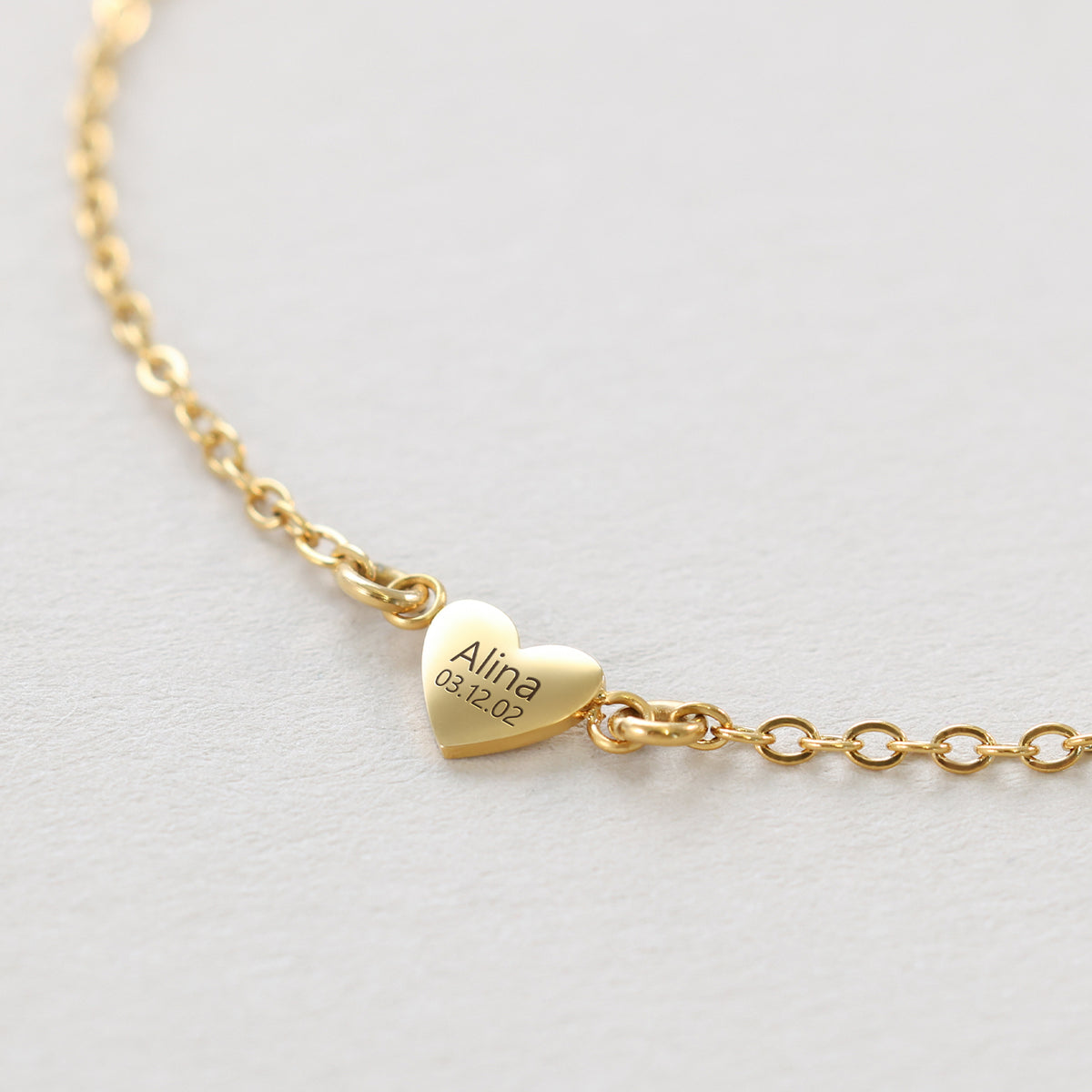 Personalisiertes Herz Armband mit Gravur, Gold – Nahaufnahme Herz-Anhänger mit Gravur Alina und Geburtsdatum