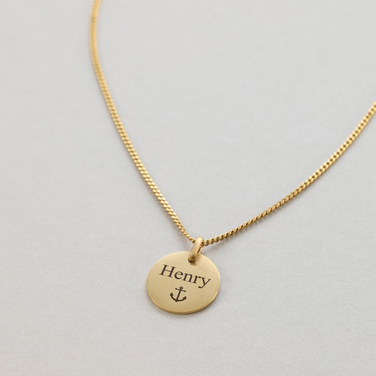 Mattes Rundplättchen in Gold graviert mit Namen 'Henry' und Anker-Symbol
