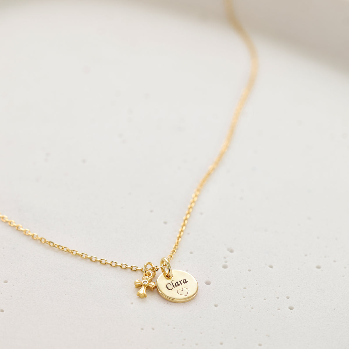 Gravurkette mit kleinem funkelnden Kreuz – 925 Sterling Silber, Kette unscharf, Anhänger im Hintergrund