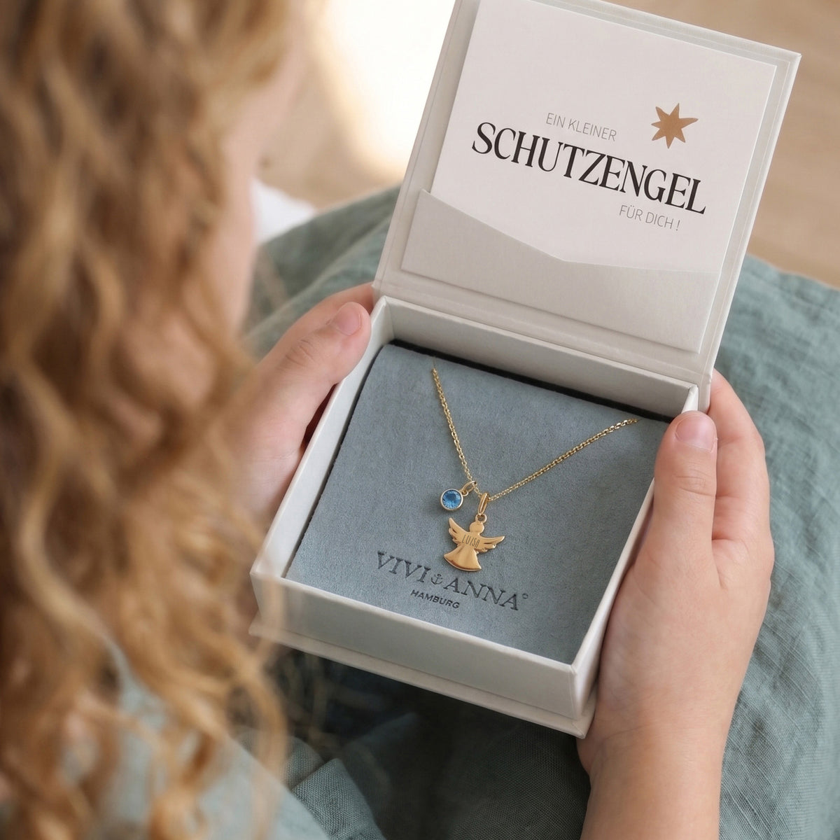 Geöffnete Geschenkbox mit Schutzengel Halskette in Gold und Grußkarte 'Ein kleiner Schutzengel für dich'