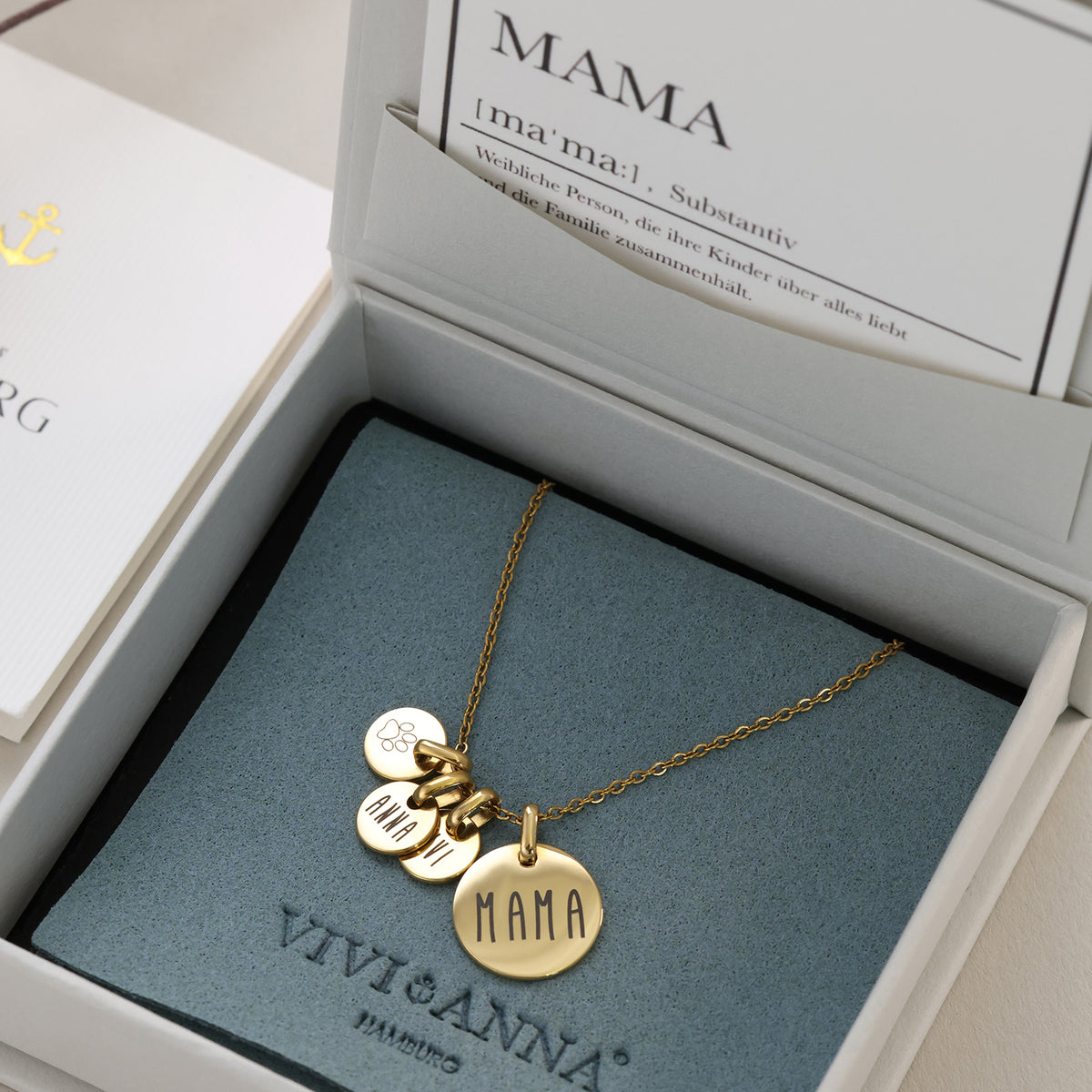 Familienkette in Gold mit Plättchen 'Mama' und Namen in Box mit Mama-Definitionskarte