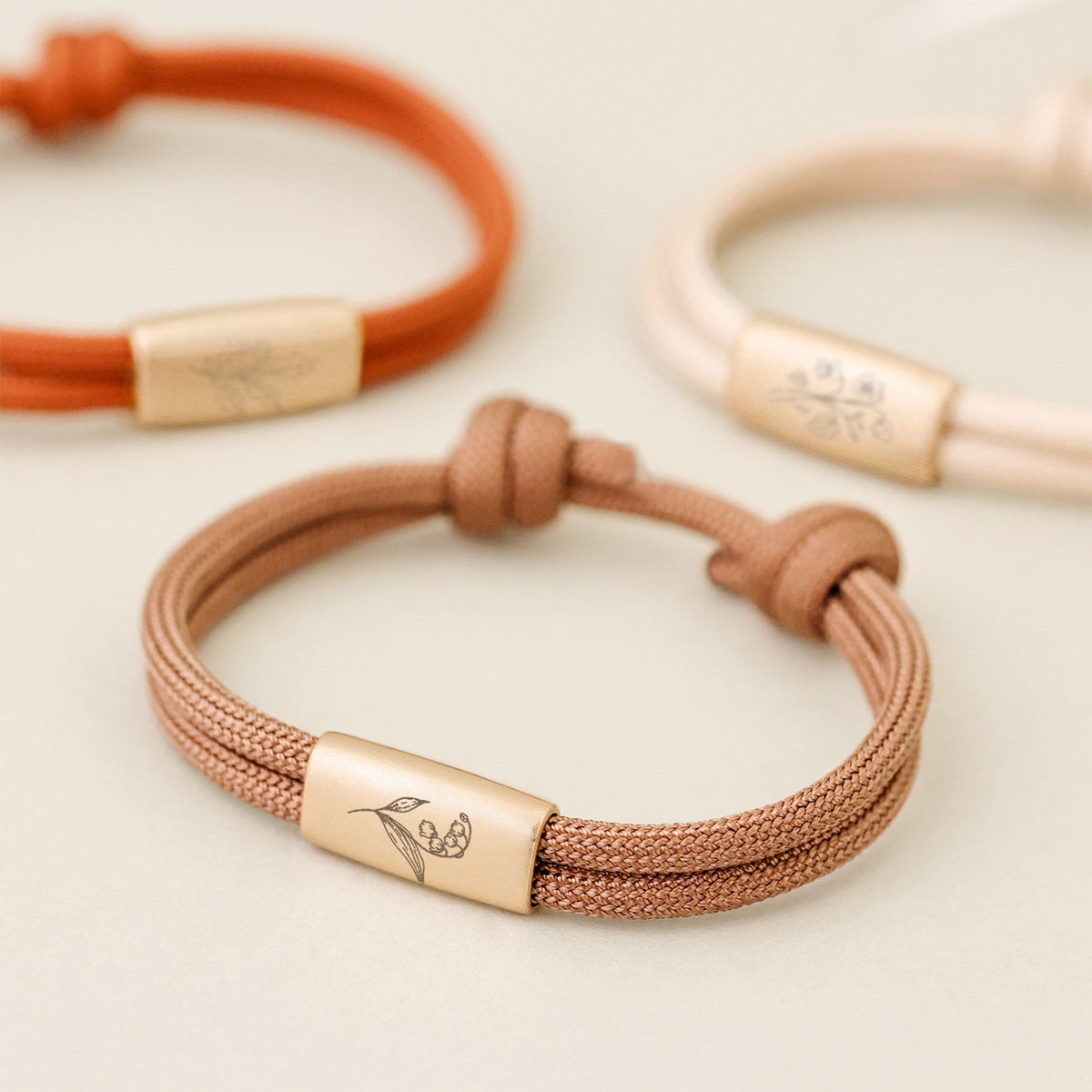 Geburtsblumen Armband aus Segeltau mit Wunschgravur – Nahaufnahme der Gravurplatte in Rostrot, Terrakotta und Creme