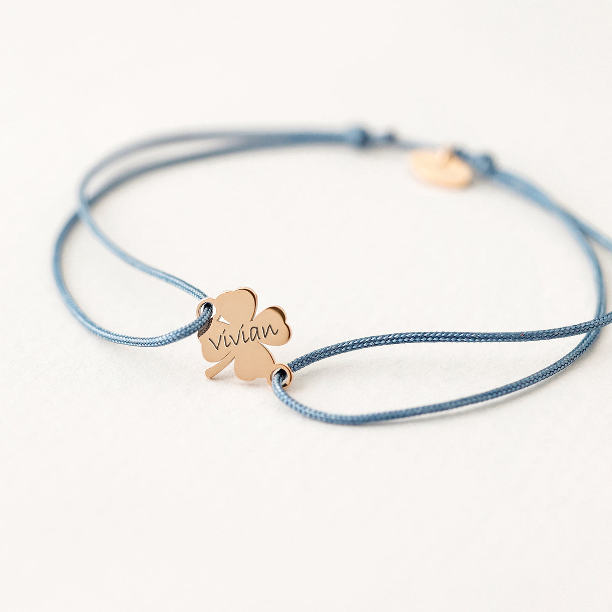 Glücksbringer Armband mit Kleeblatt in Roségold, graviert mit dem Namen Vivian, graublaues Band