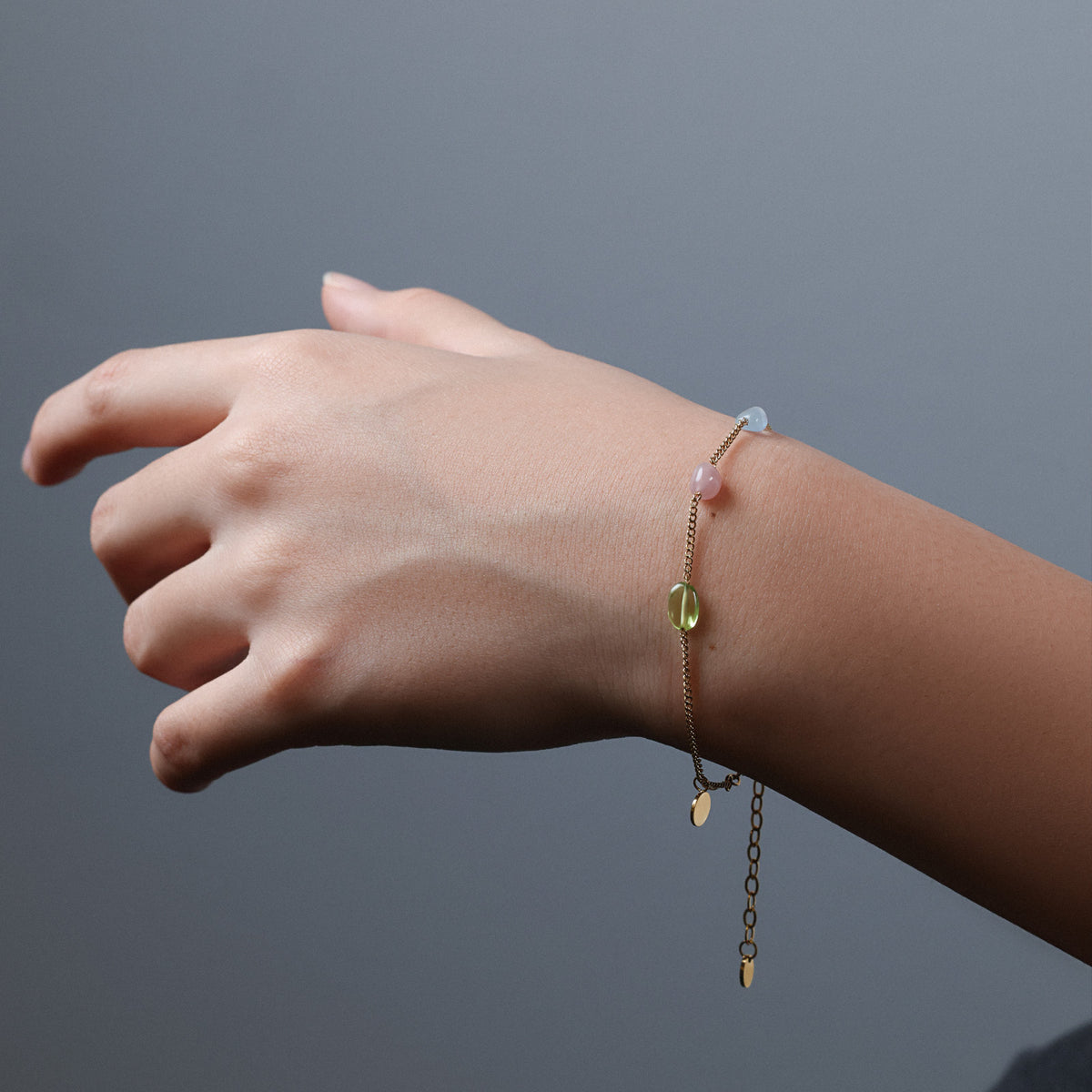 Naturstein-Energiearmband am Arm getragen, Nahaufnahme der bunten Perlen und Kette