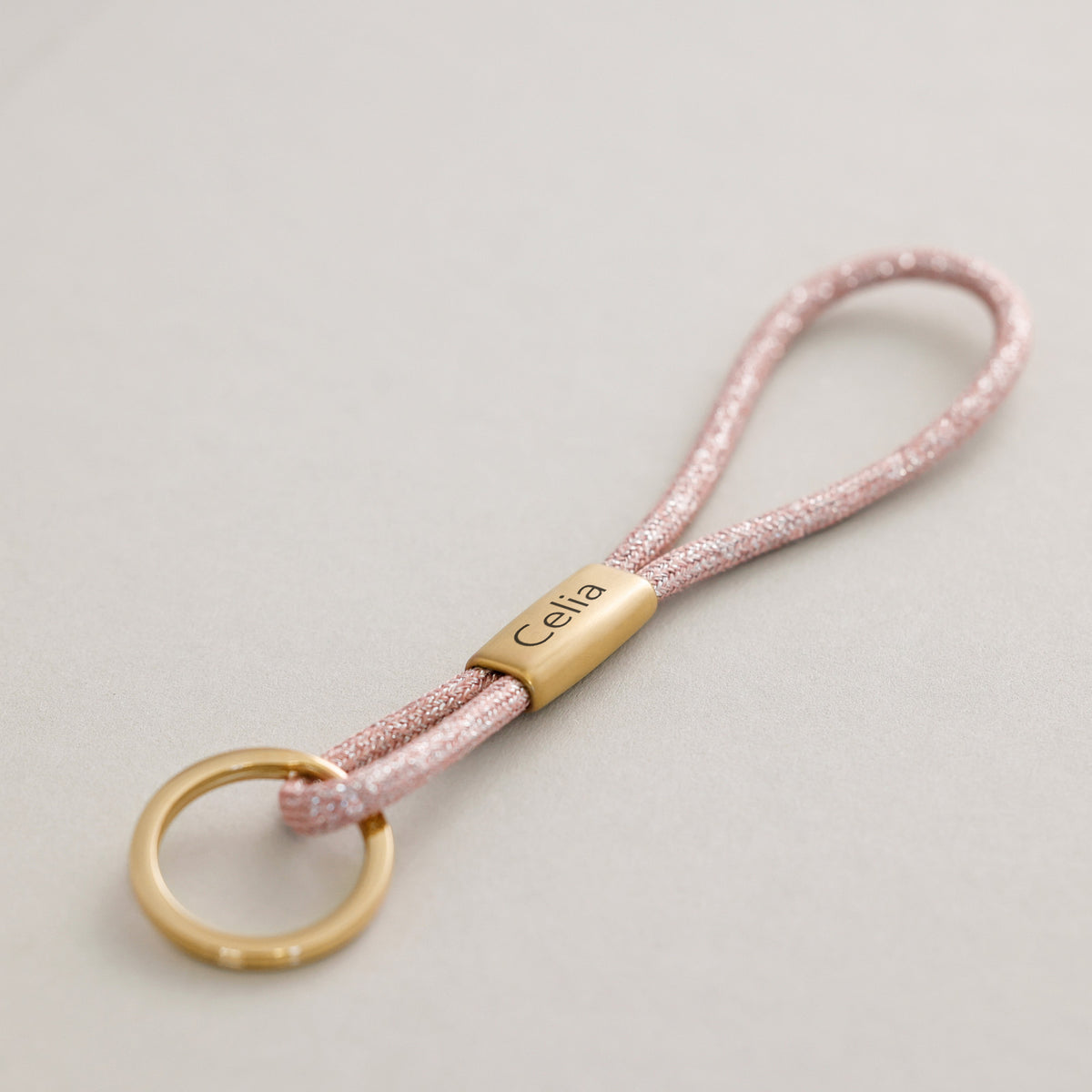 Rosefarbenes Glitzer-Schlüsselband mit goldenem Steg und Gravur 'Celia' am Ring