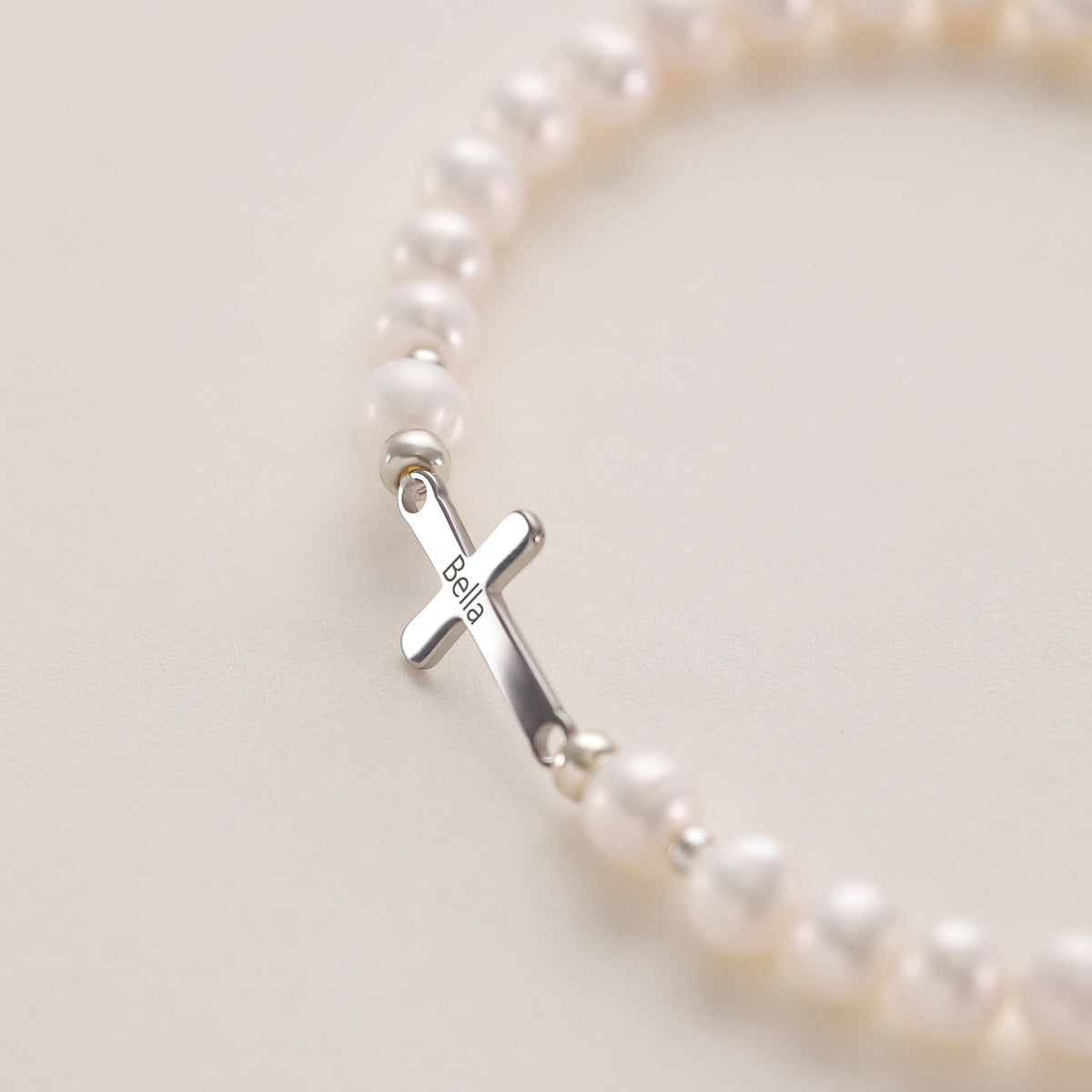 Süßwasserperlen Armband – Nahaufnahme des Kreuzanhängers mit Gravur „Bella“