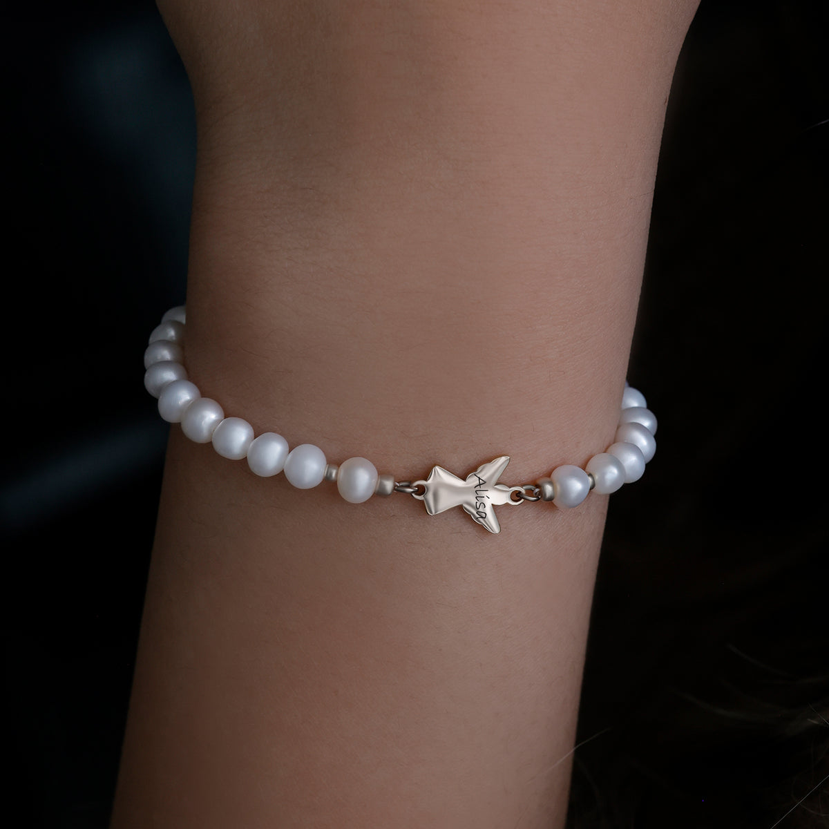 Kind trägt Engel Armband mit Süßwasserperlen in Silber am Handgelenk