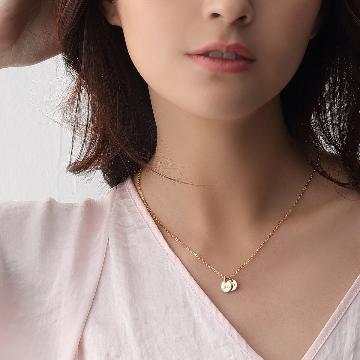 Model trägt personalisierte Mini Plättchen Halskette in Gold mit Namensgravur