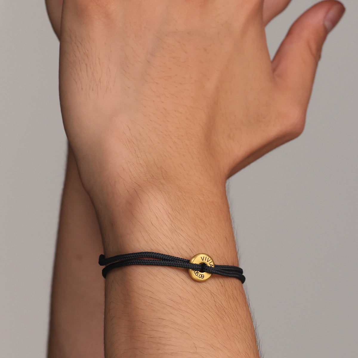 Segeltau Donut Armband in Schwarz-Gold mit Gravur am Handgelenk in Nahaufnahme