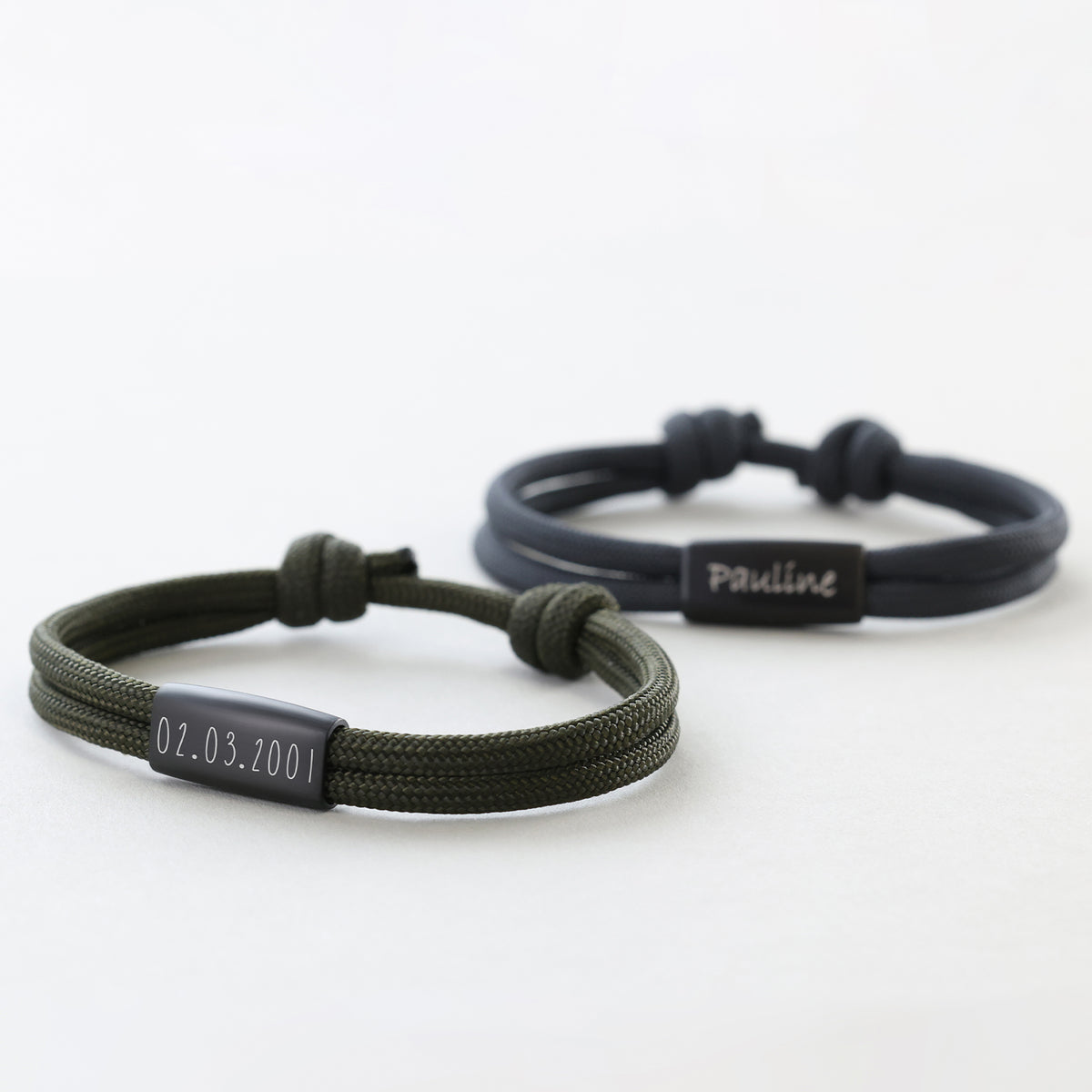 Zwei personalisierte Segeltau Armbänder in Oliv und Schwarz – Datum '02.03.2001' und Name 'Pauline' graviert