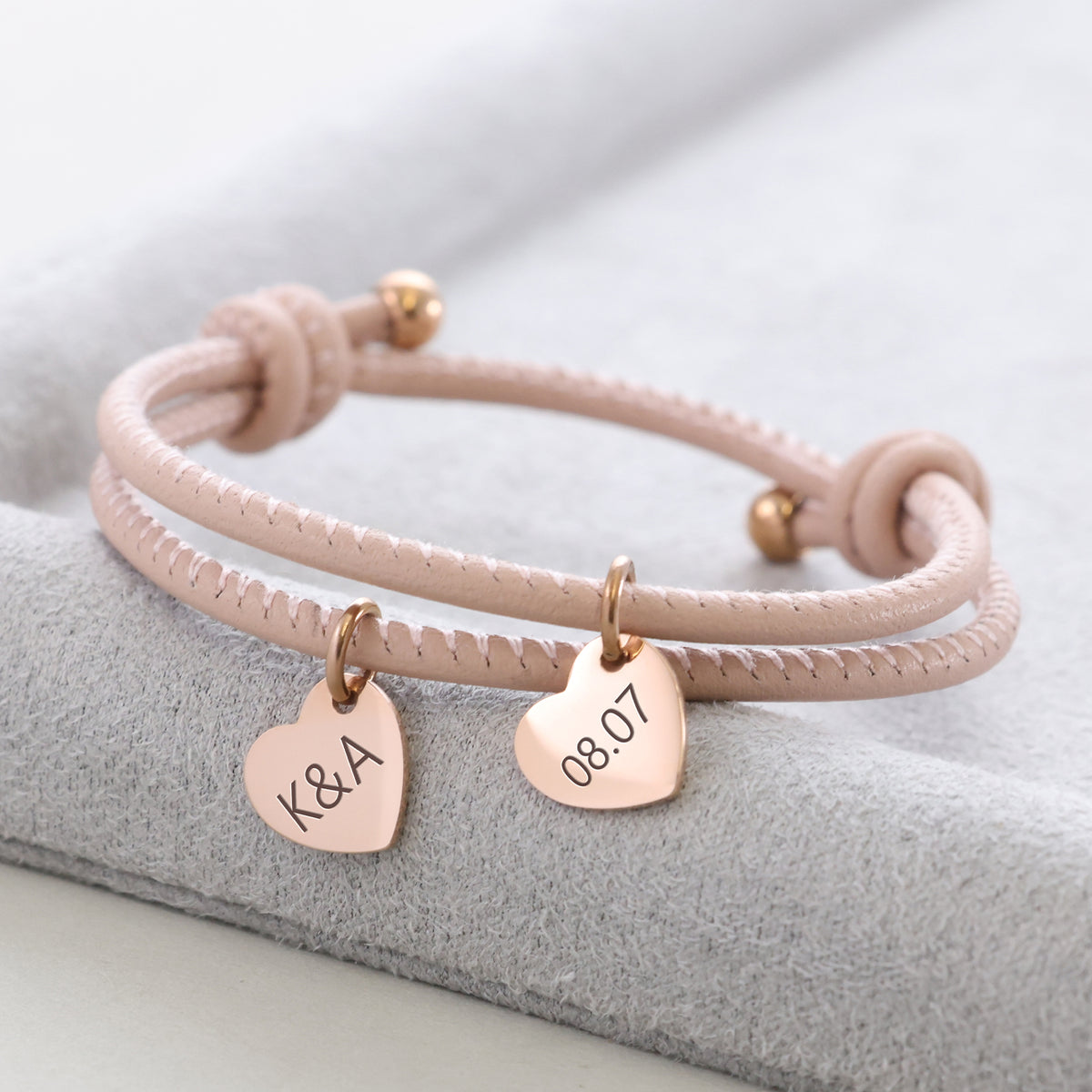 Herz-Anhänger Lederarmband mit Gravur in Rosé – zwei Herzanhänger mit 'K&A' und Datum '08.07'