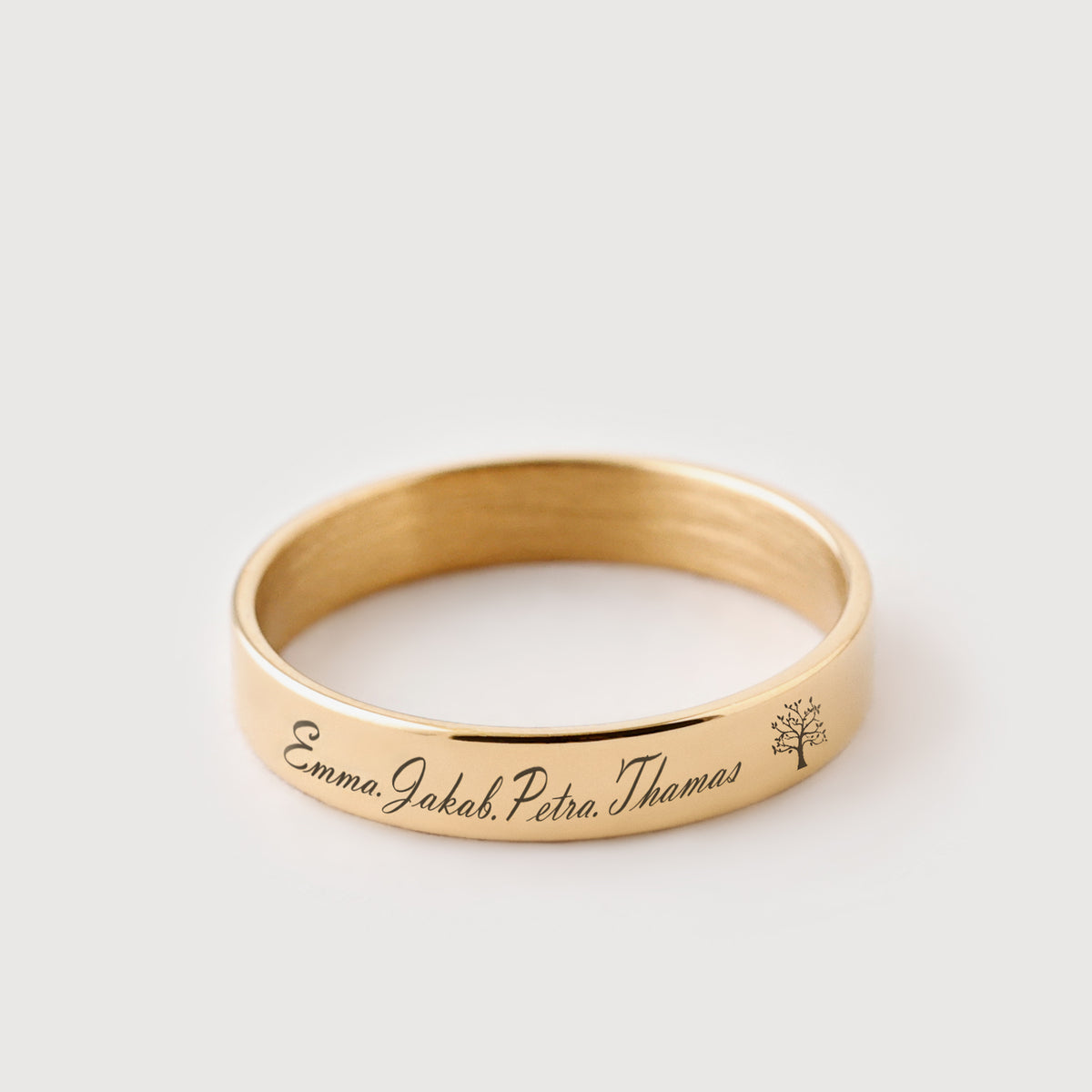 Minimalist Ring mit Gravur in Gold, Namen 'Emma, Jakob, Petra, Thomas' und kleines Baum-Symbol