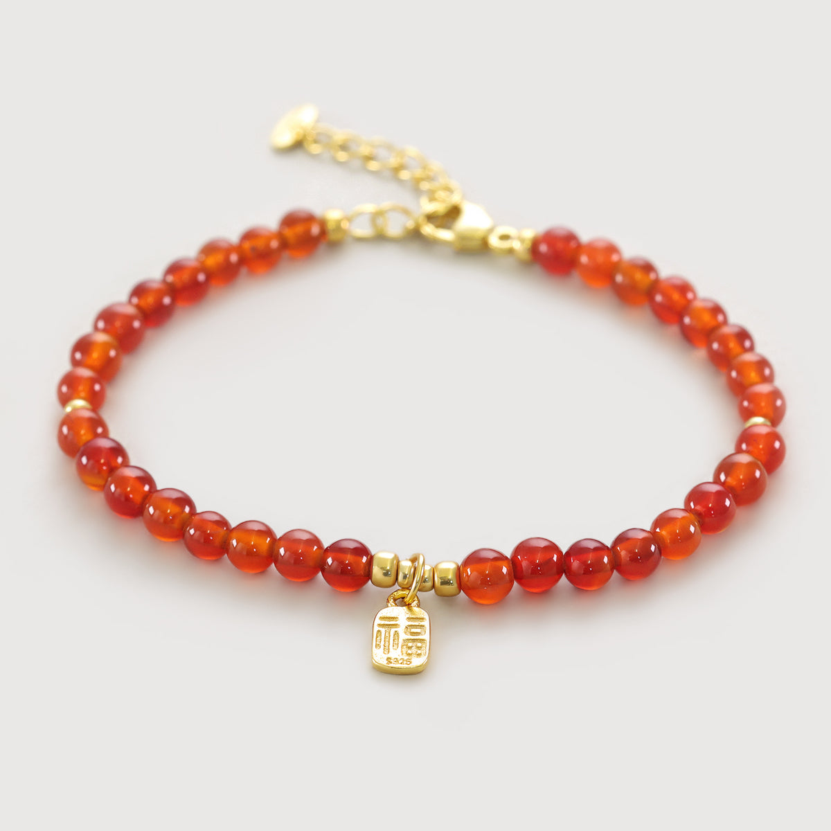 Karneol Armband mit goldenem „福“-Anhänger, freigestellt auf hellem Hintergrund