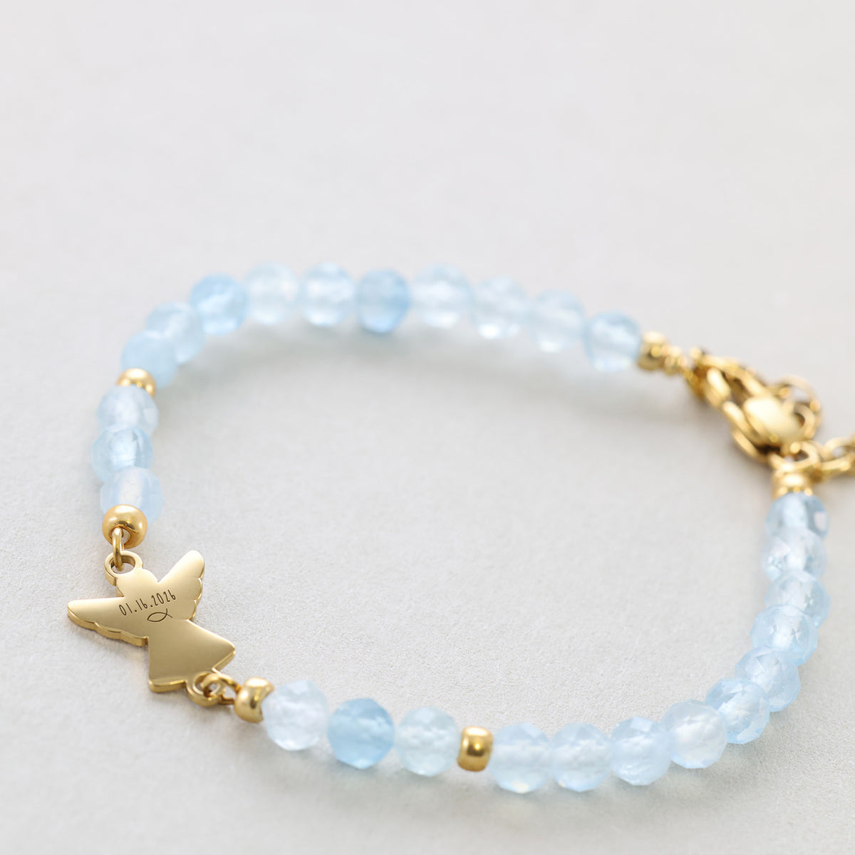Aquamarin Armband mit Engelanhänger in Gold, graviert mit Datum, freigestellt