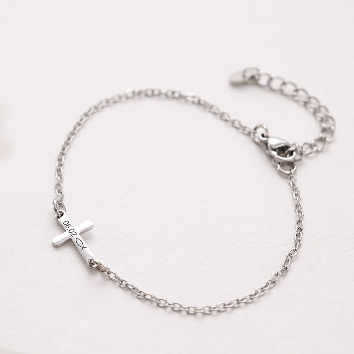 Kreuz-Armband mit Gravur in Silber, Kreuz graviert mit Datum 06.02 und Fischsymbol