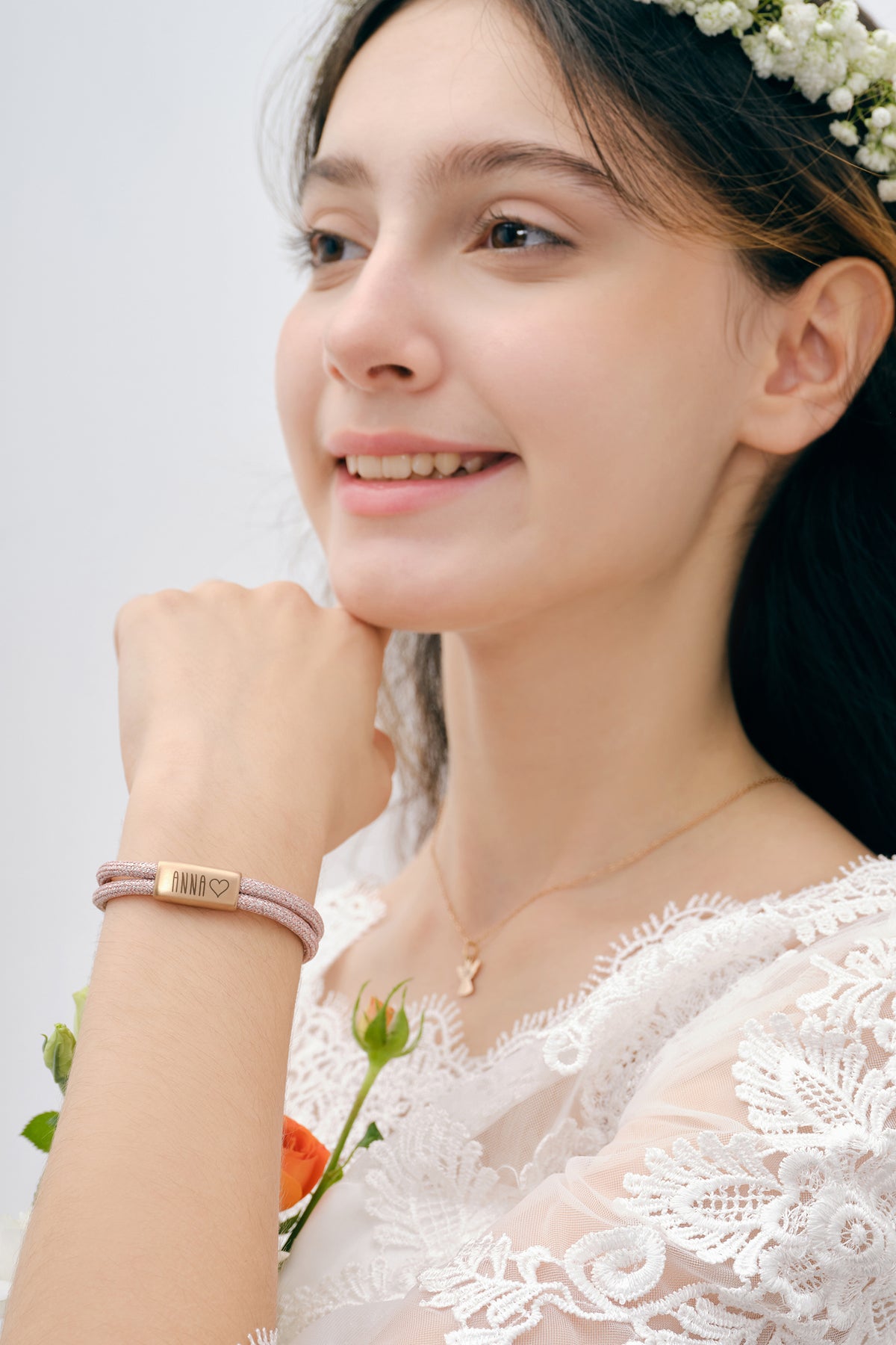 Mädchen trägt Glitzer Segeltau Armband in Rosé mit graviertem Plättchen 'Anna' und Herz