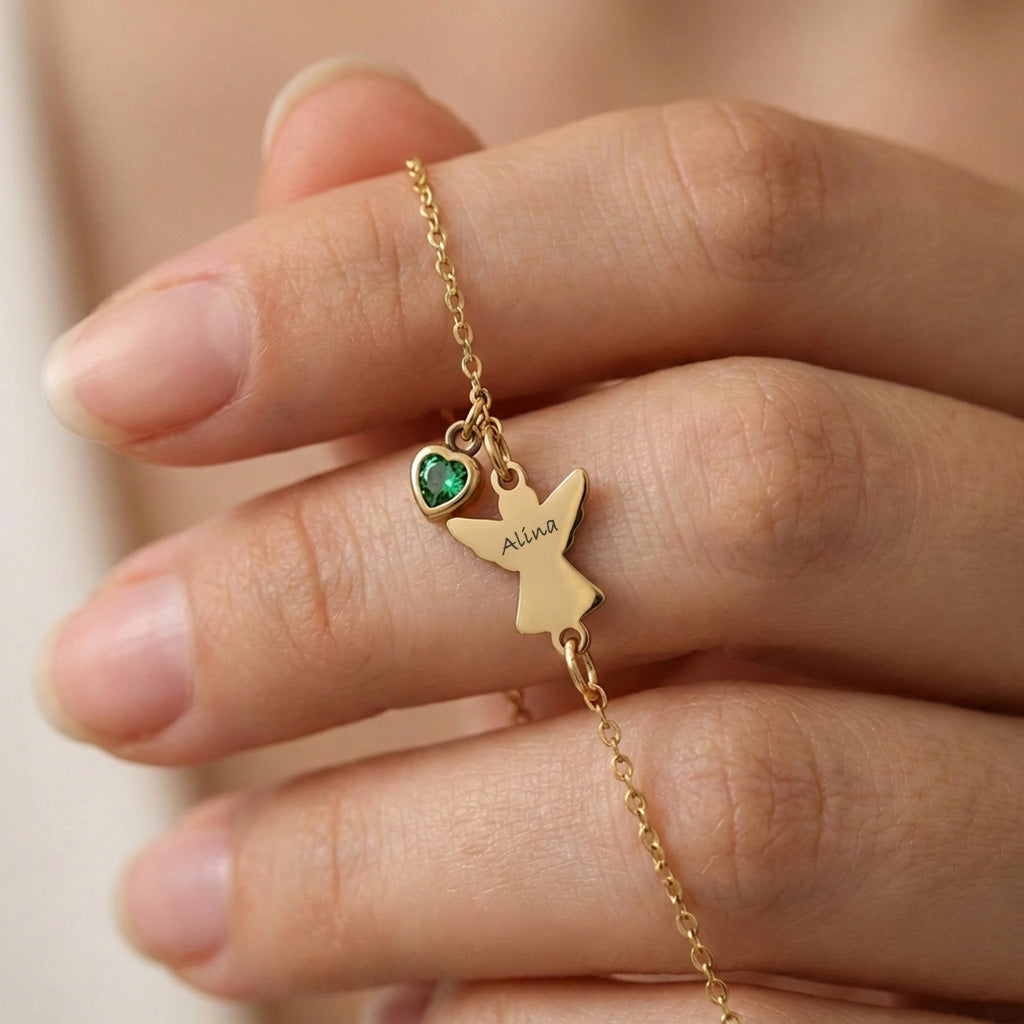 Engel Armband mit Zirkonia Geburtsstein – Nahaufnahme des gravierten Anhängers zwischen den Fingern gehalten