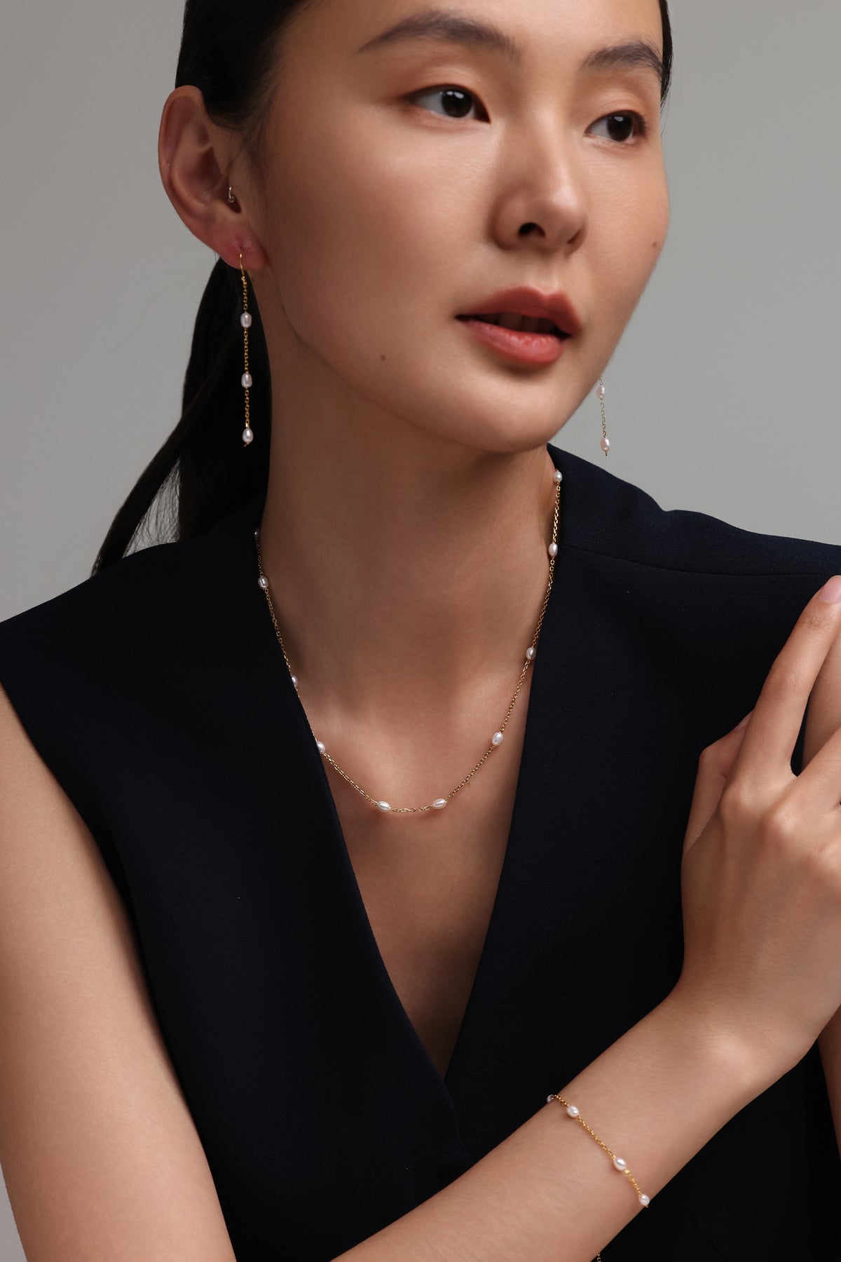 Zarte Kette mit Süßwasserperlen - 925 Sterling Silber, Frau trägt Kette, Ohrringe und Armband im Porträt