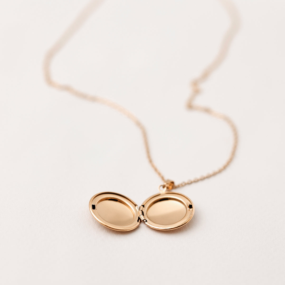 Medaillon Kette mit personalisierter Gravur in Gold – geöffnetes ovales Medaillon mit leerem Fotofach