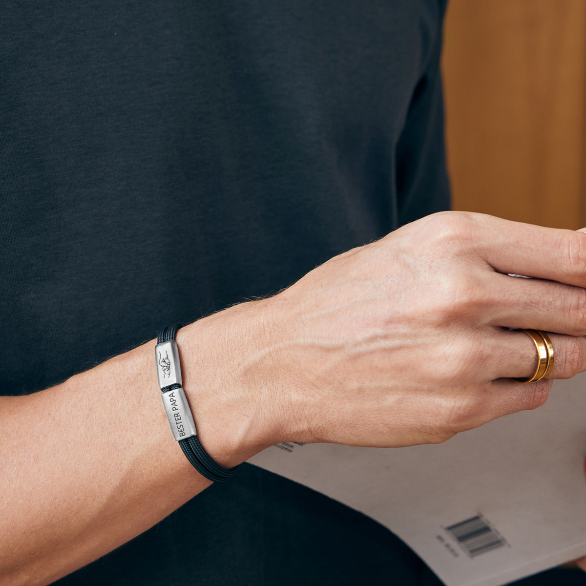 Mann trägt Herrenarmband mit Gravurperlen 'Bester Papa' am Handgelenk, Nahaufnahme