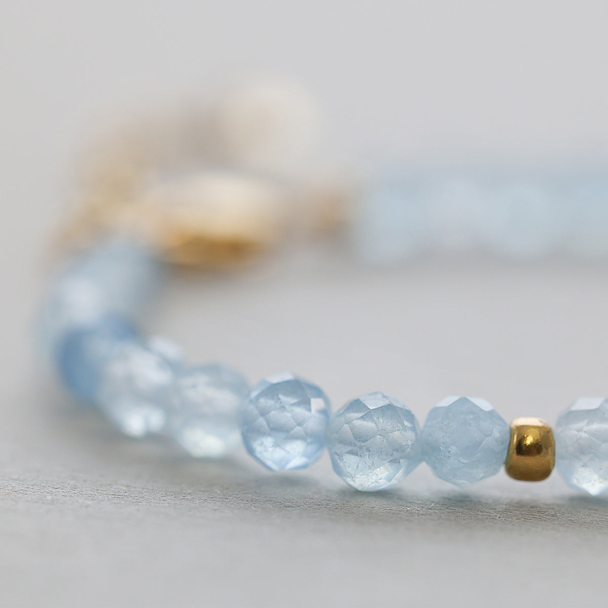 Detailansicht der facettierten Aquamarin-Perlen am Armband mit Engelanhänger