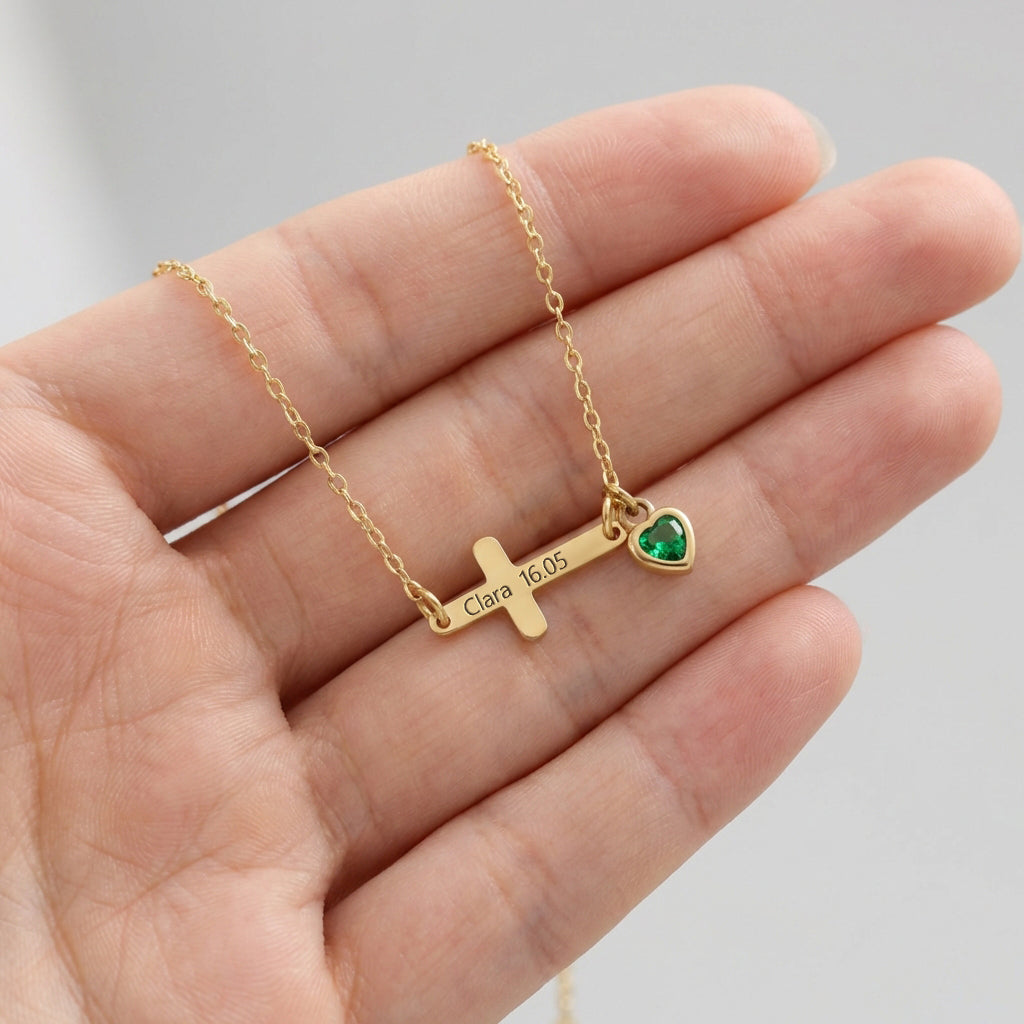 Kreuz Armband mit Zirkonia Geburtsstein in Gold – auf der Hand liegend, graviert mit Name und Datum