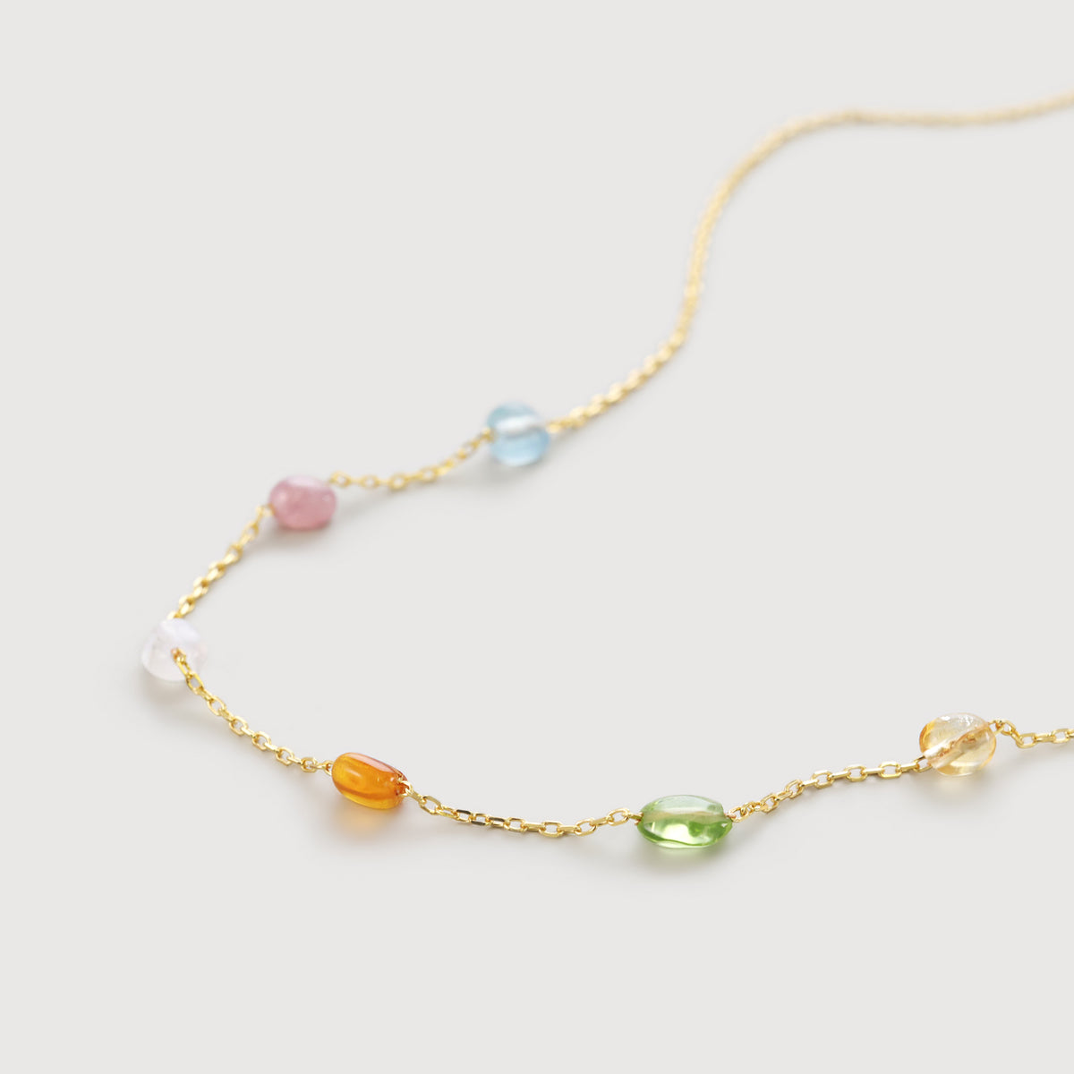 Goldkette mit bunten Edelstein-Stationen in Blau, Rosa, Grün und Bernstein, Nahaufnahme