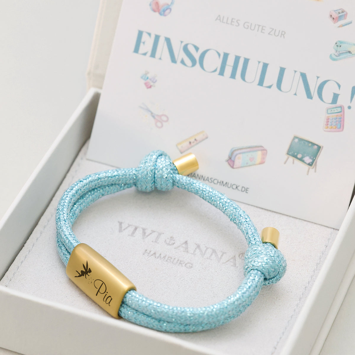 Glitzerndes Segeltau-Armband mit persönlicher Gravur in Hellblau, Gravur Pia mit Libellen-Symbol, mit Einschulungskarte