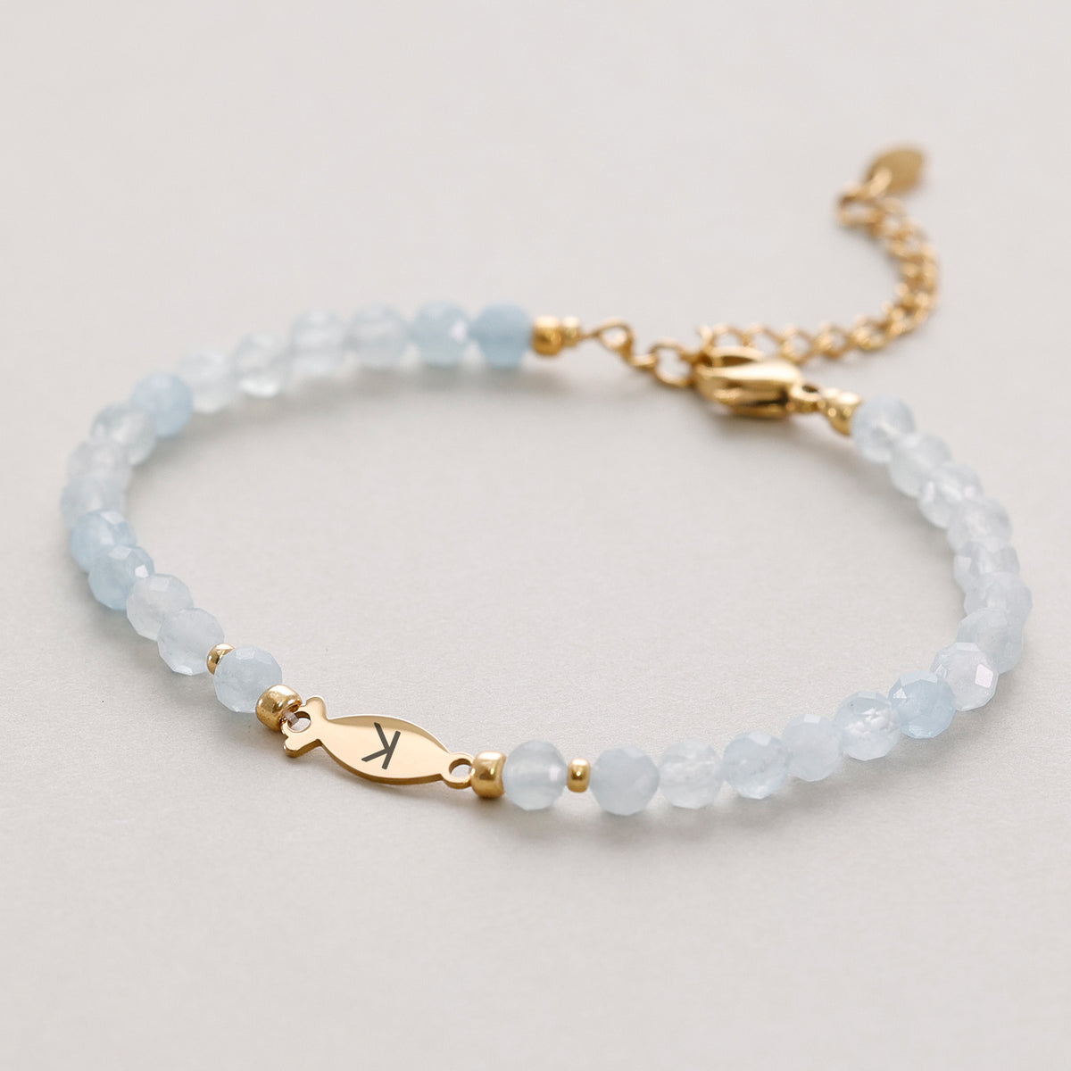 Aquamarin Ichthys-Armband mit goldenem Fischanhänger, graviert mit Initiale 'K'