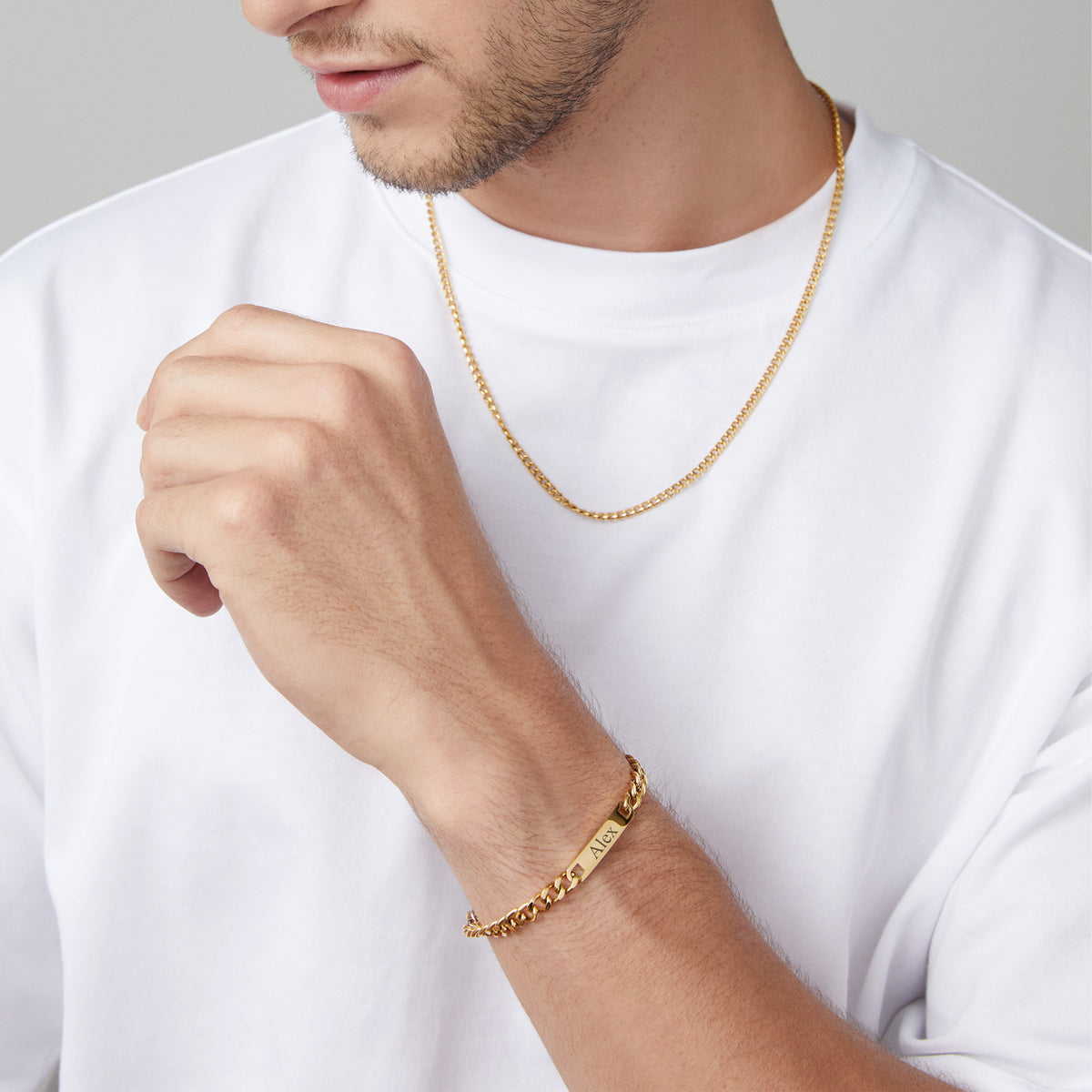 Mann trägt goldene Halskette und graviertes Panzerarmband mit Namen Alex